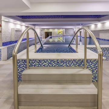 a swimming pool with stairs and railings