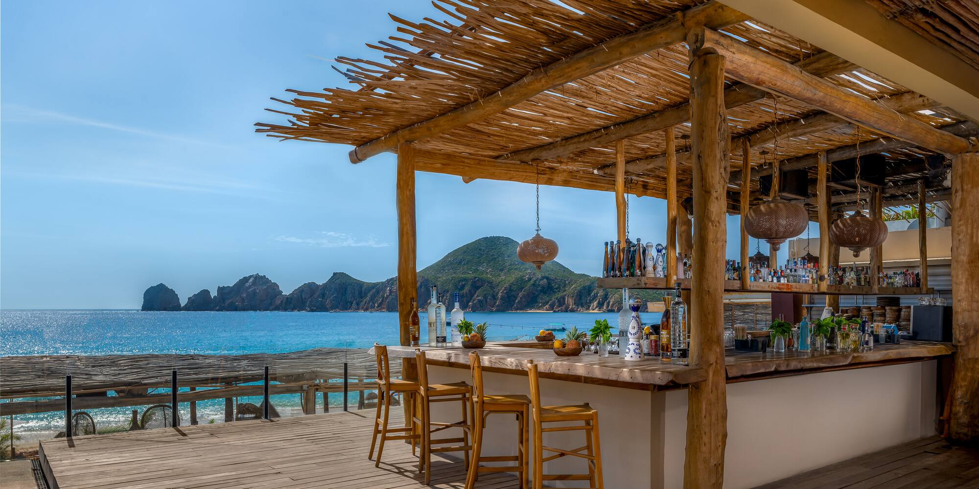a bar with chairs and a table on a beach