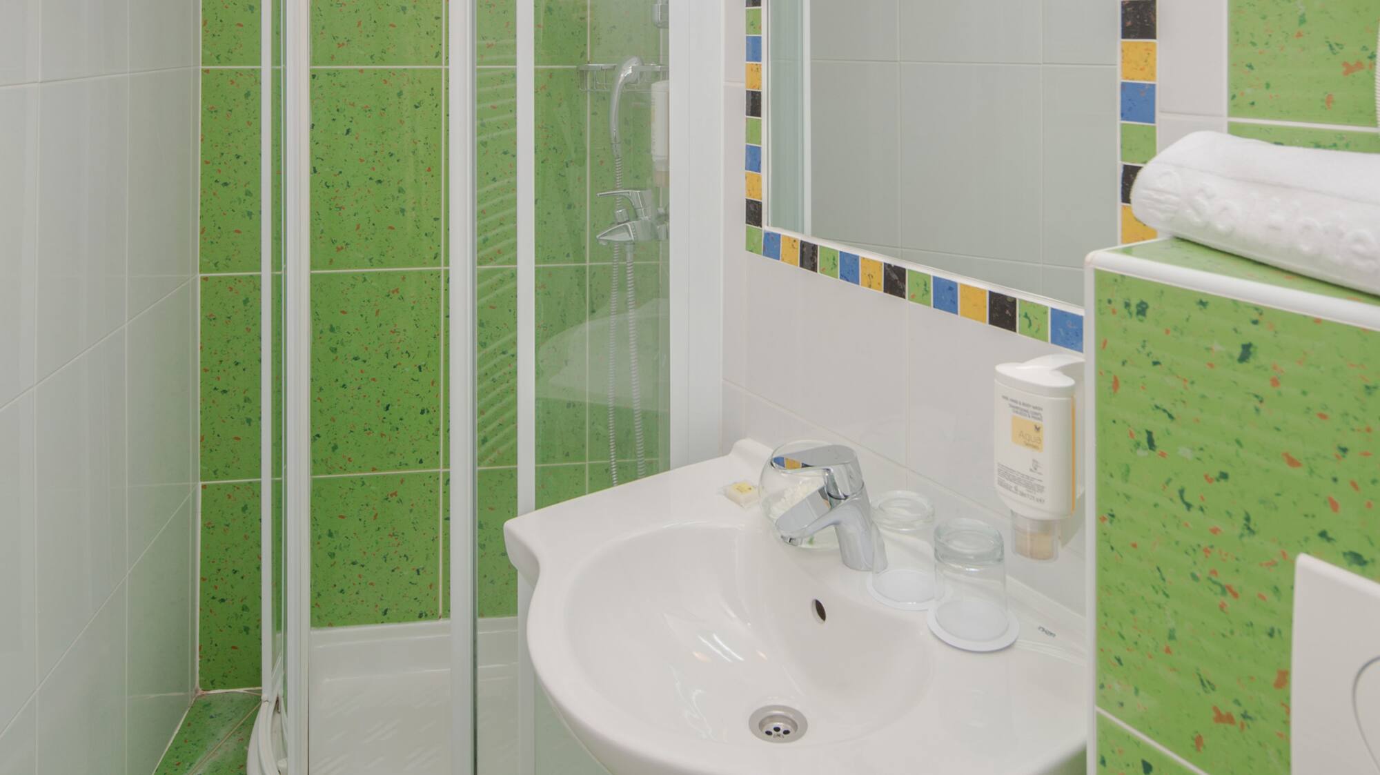 a bathroom with green tiles