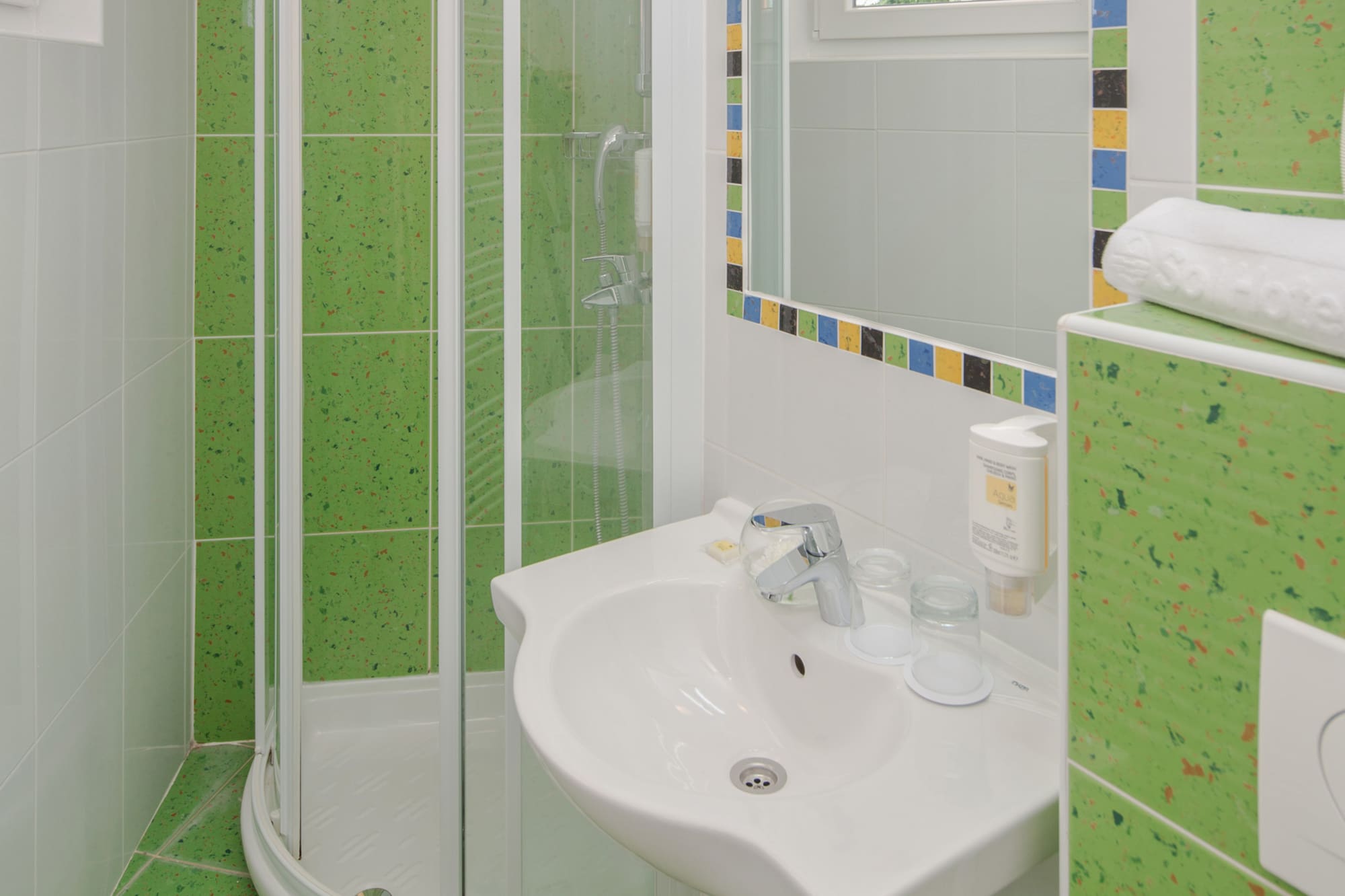 a bathroom with green tiles