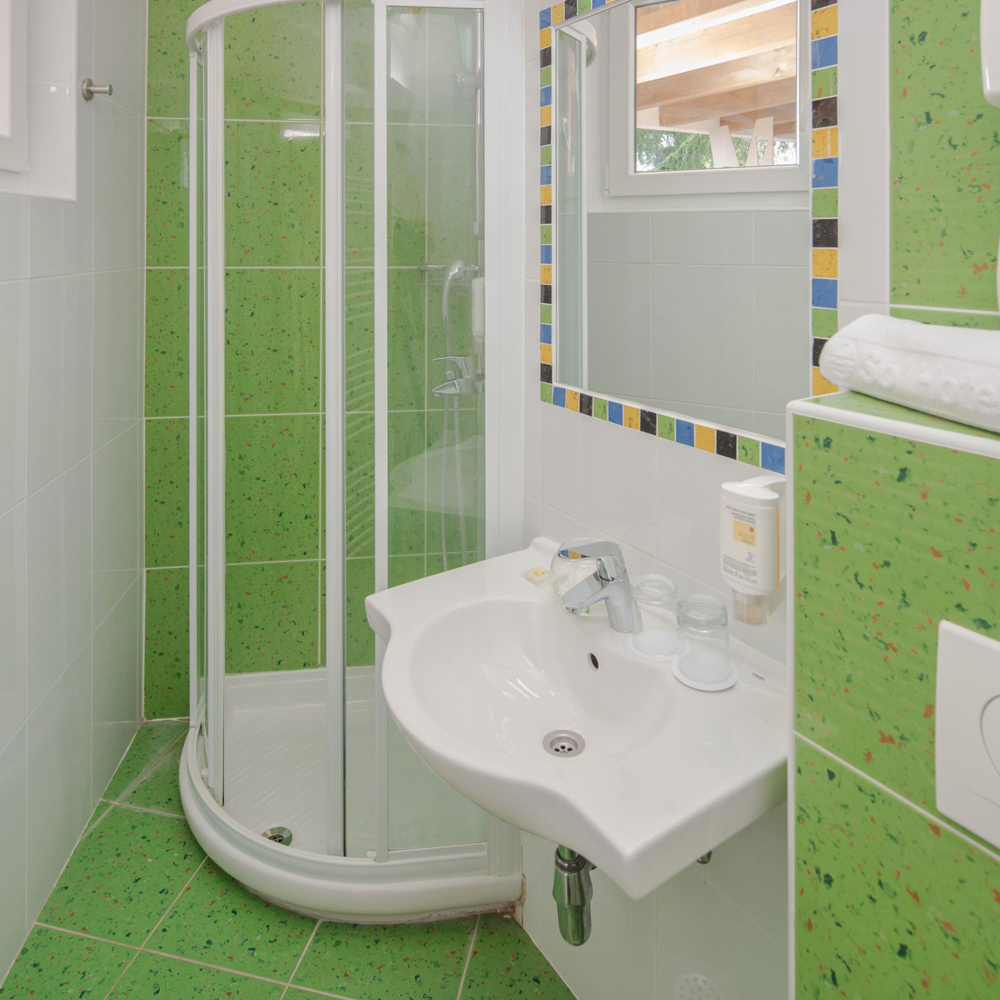 a bathroom with green tiles