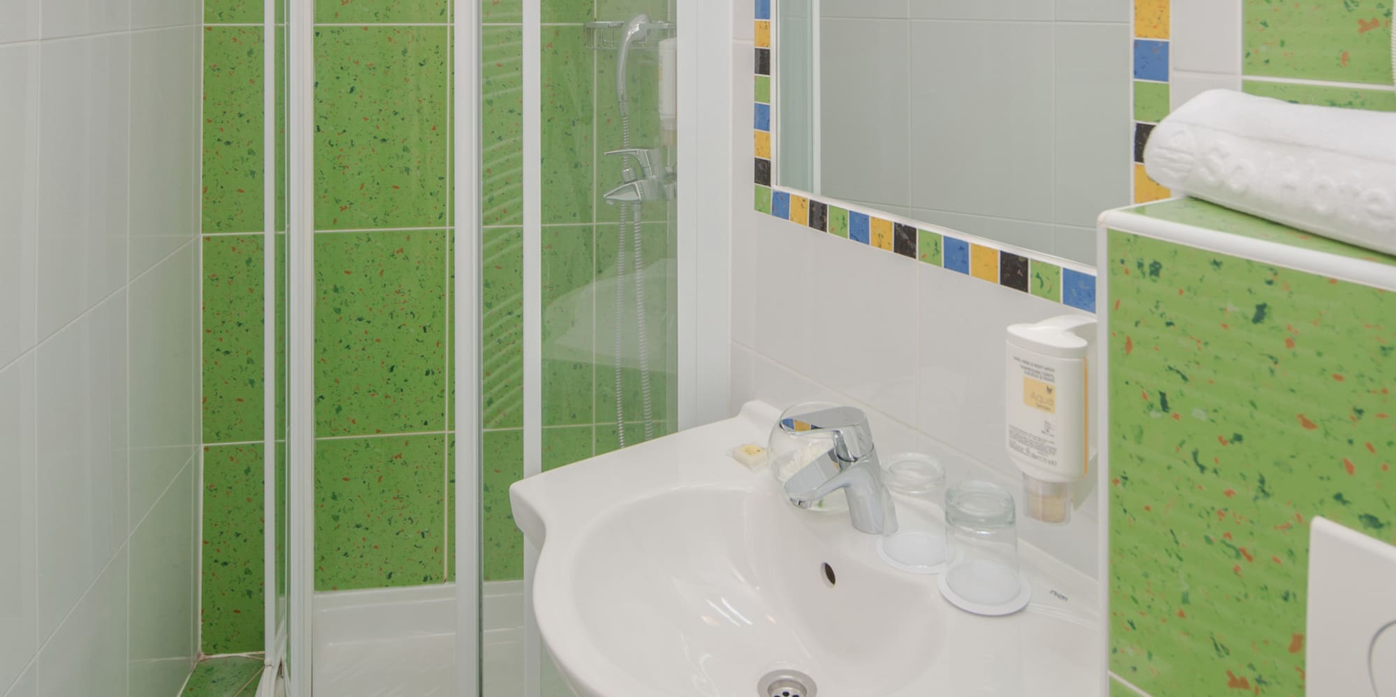 a bathroom with green tiles