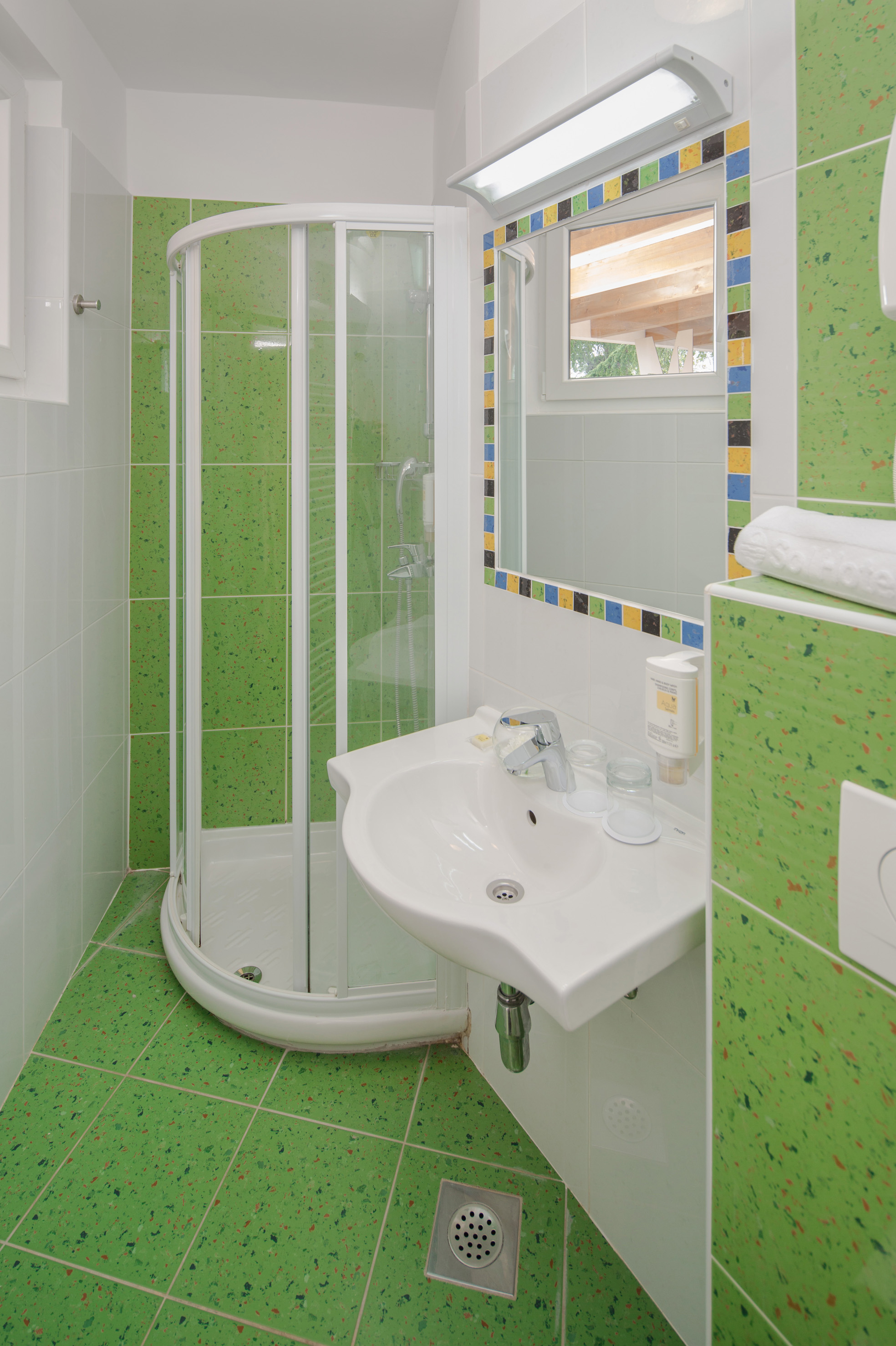 a bathroom with green tiles