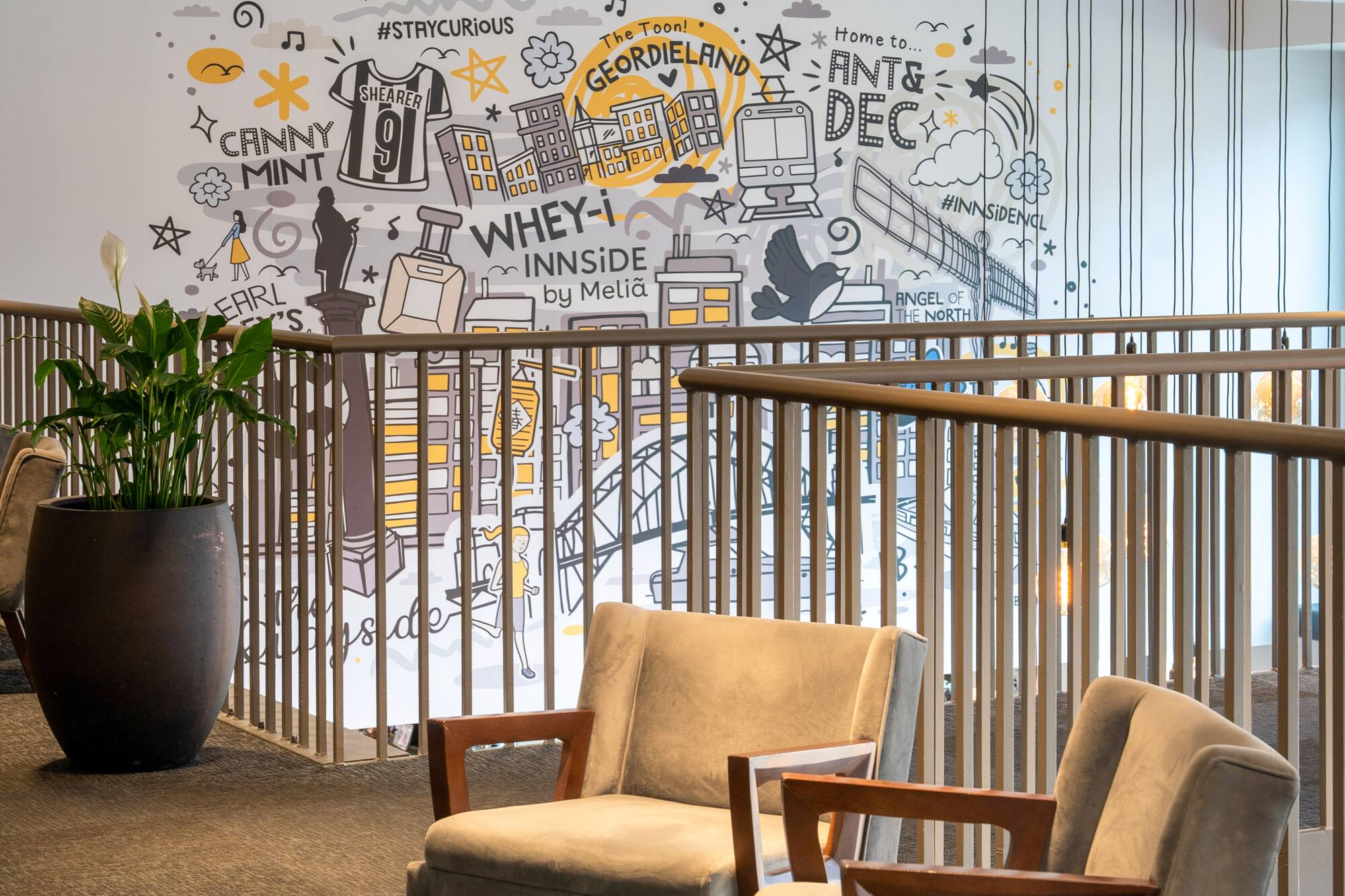INNSiDE by Meliá hotel lobby with Geordieland mural and modern armchairs.