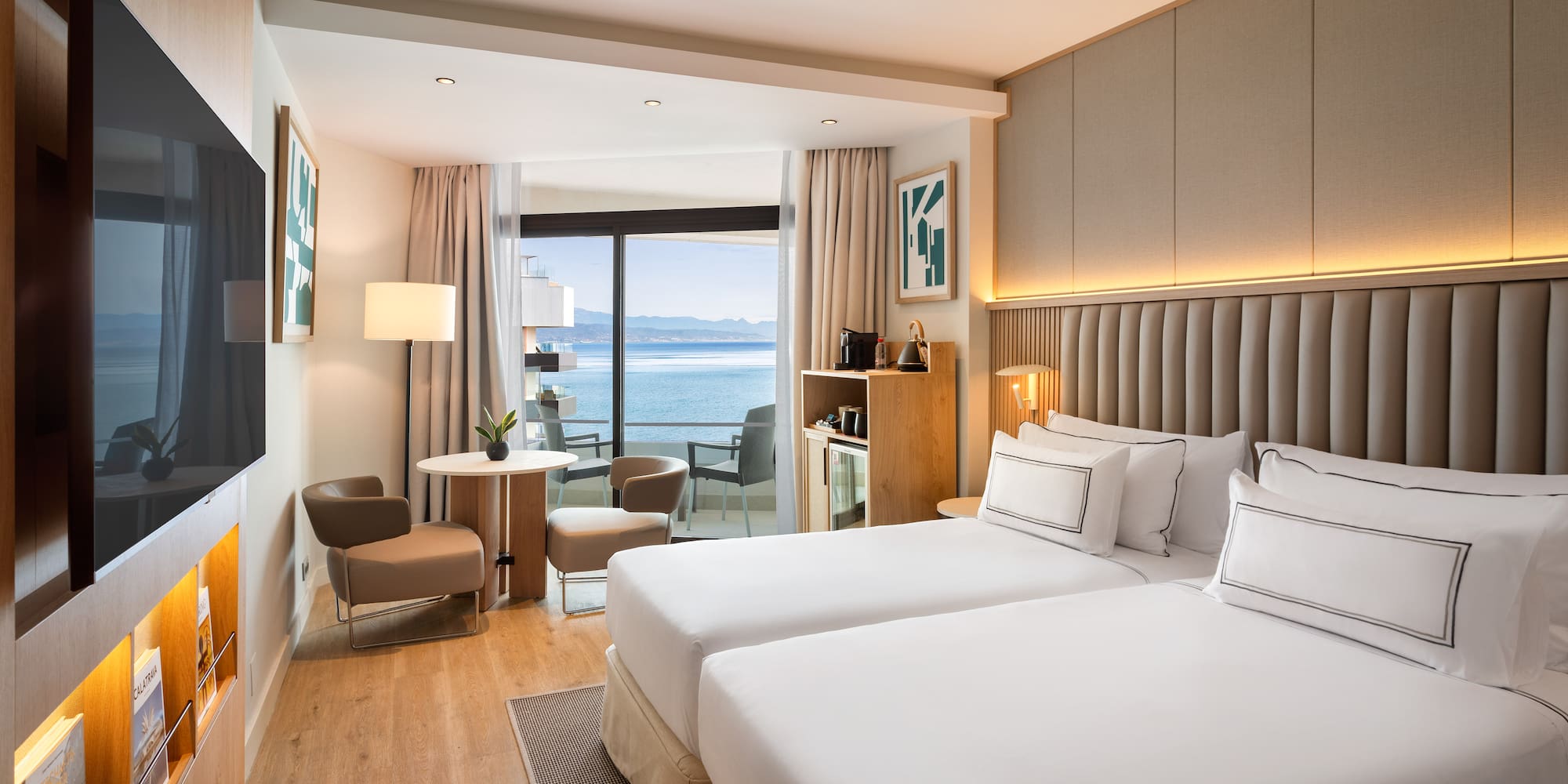 a room with two beds and a table and chairs