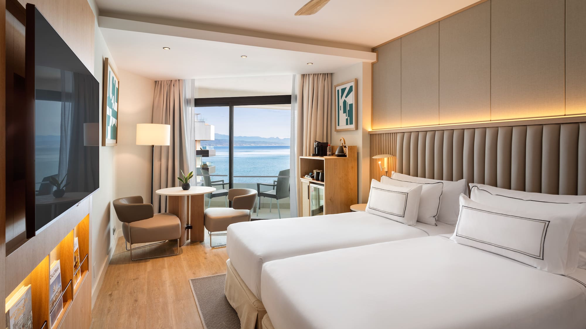 a room with two beds and a table and chairs