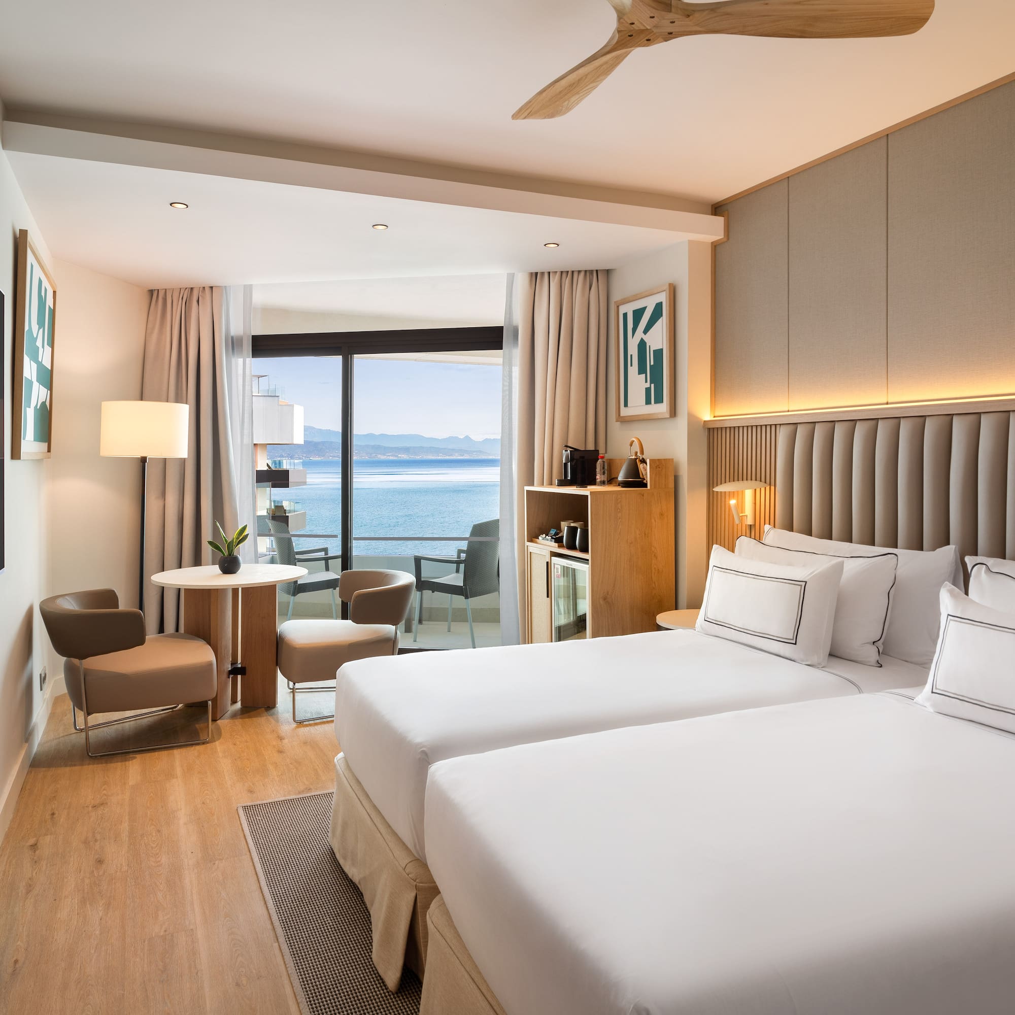 a room with two beds and a table and chairs