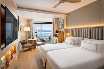 a room with two beds and a table and chairs