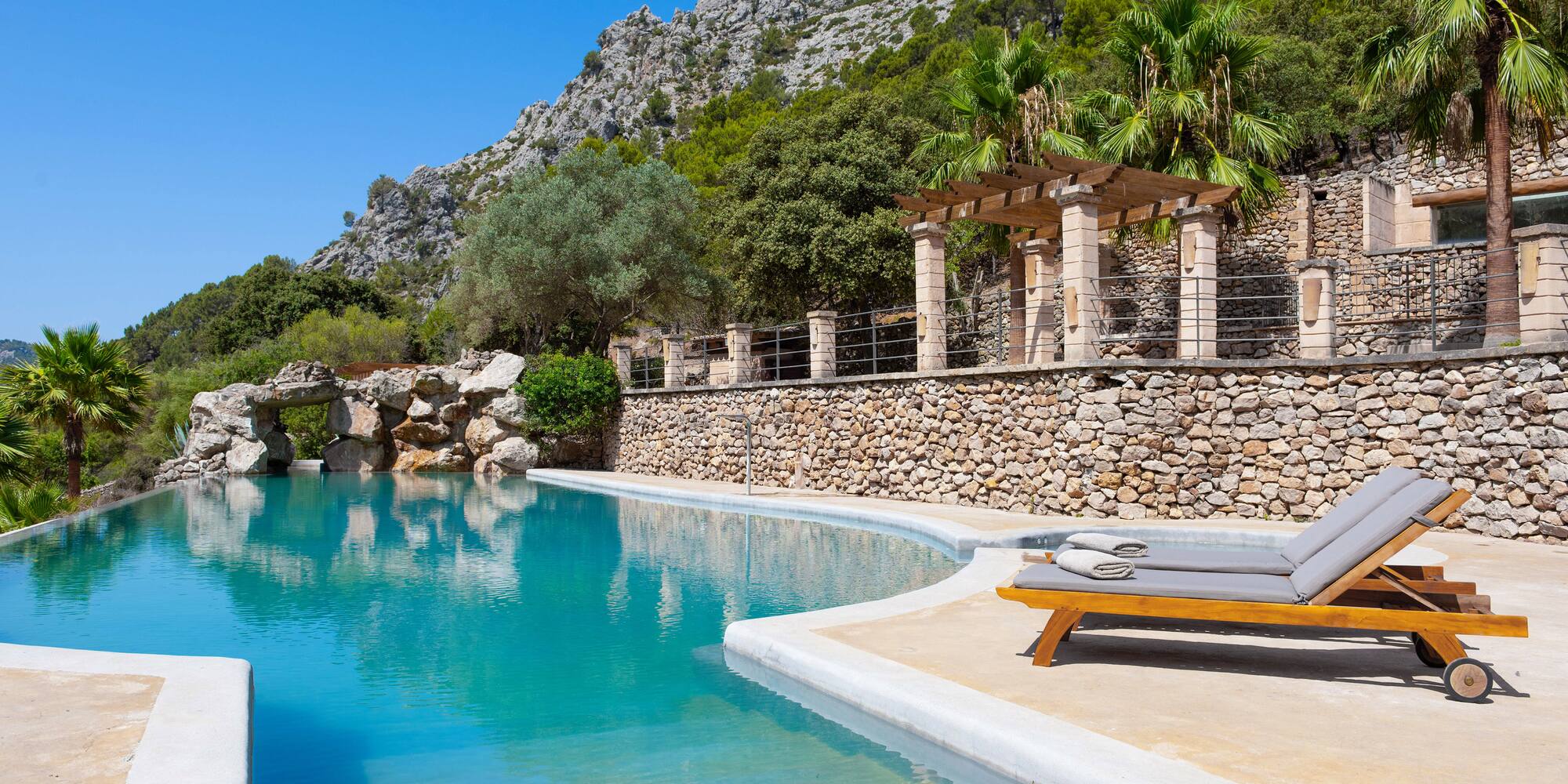 a pool with a stone wall and a stone wall and a stone wall with a stone wall and a stone wall with a stone wall and a stone wall with a stone wall and a stone wall with