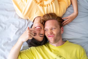 a man and woman lying on a bed