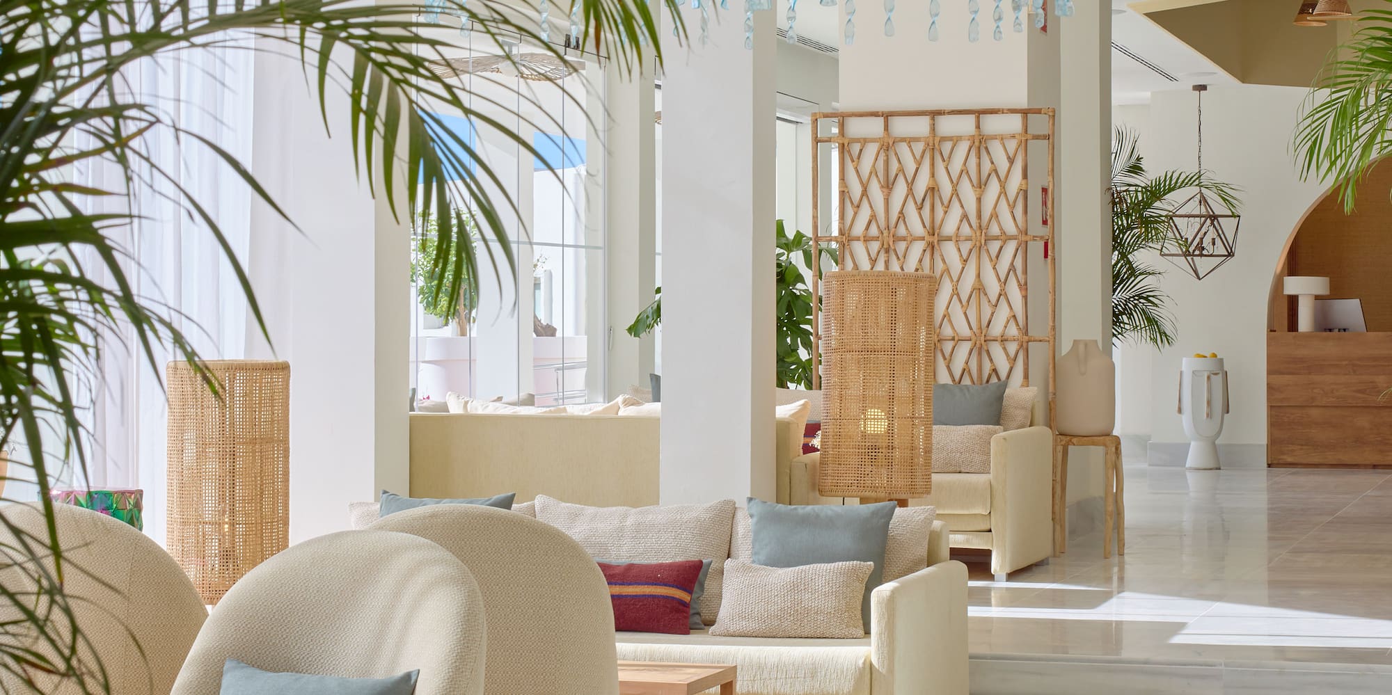 une pièce avec des meubles blancs et des plantes