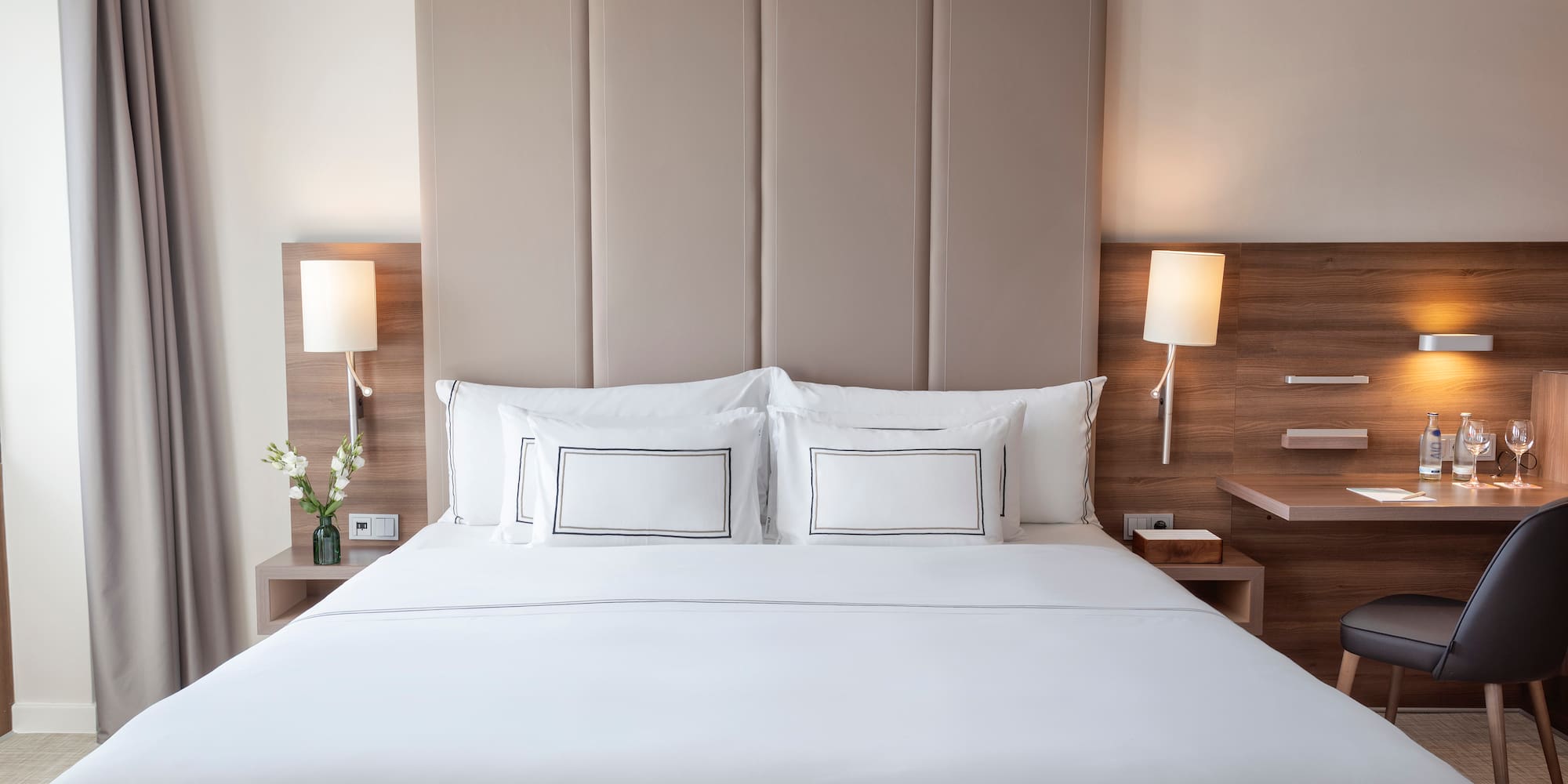 a bed with white sheets and pillows