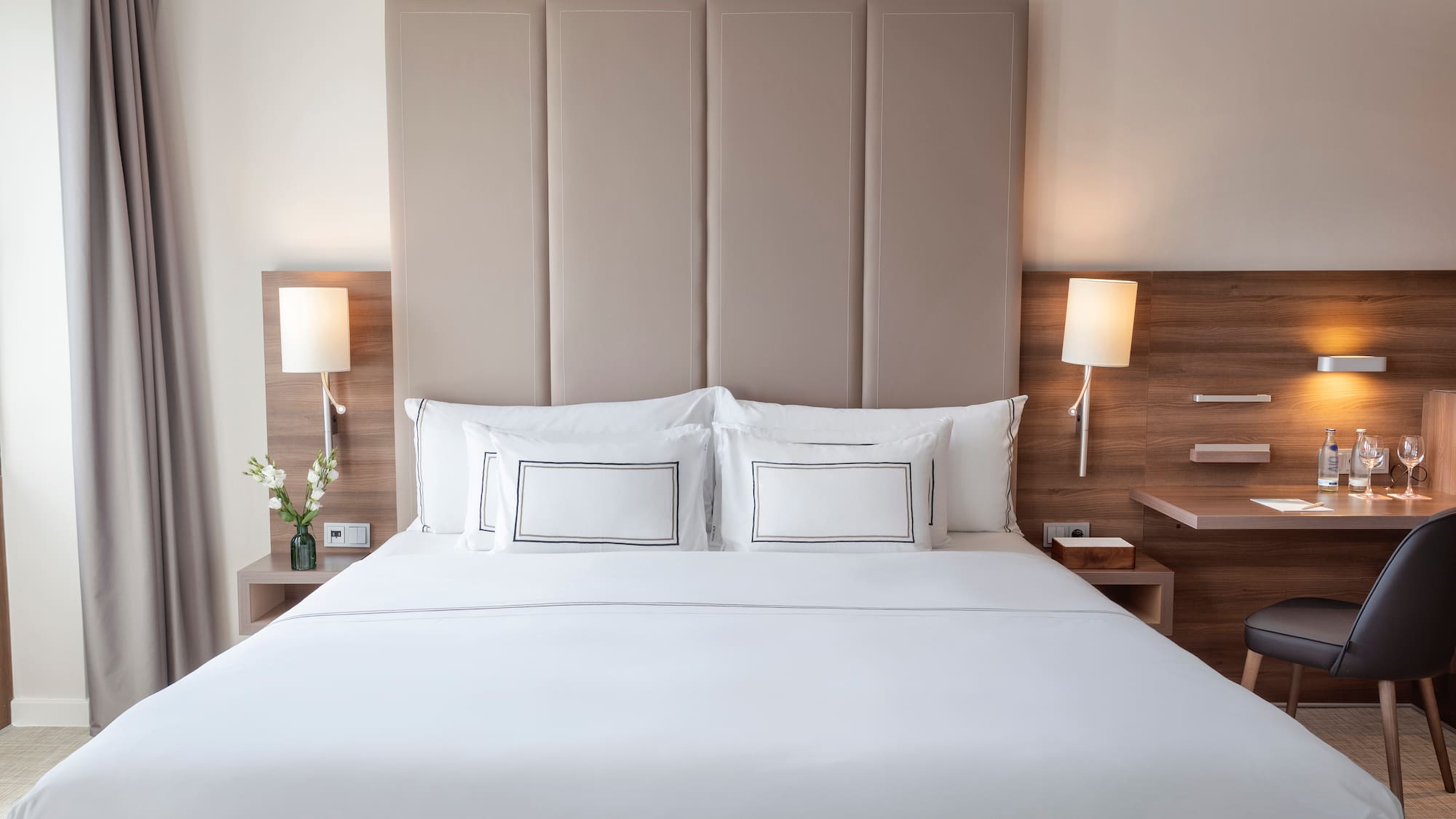 a bed with white sheets and pillows