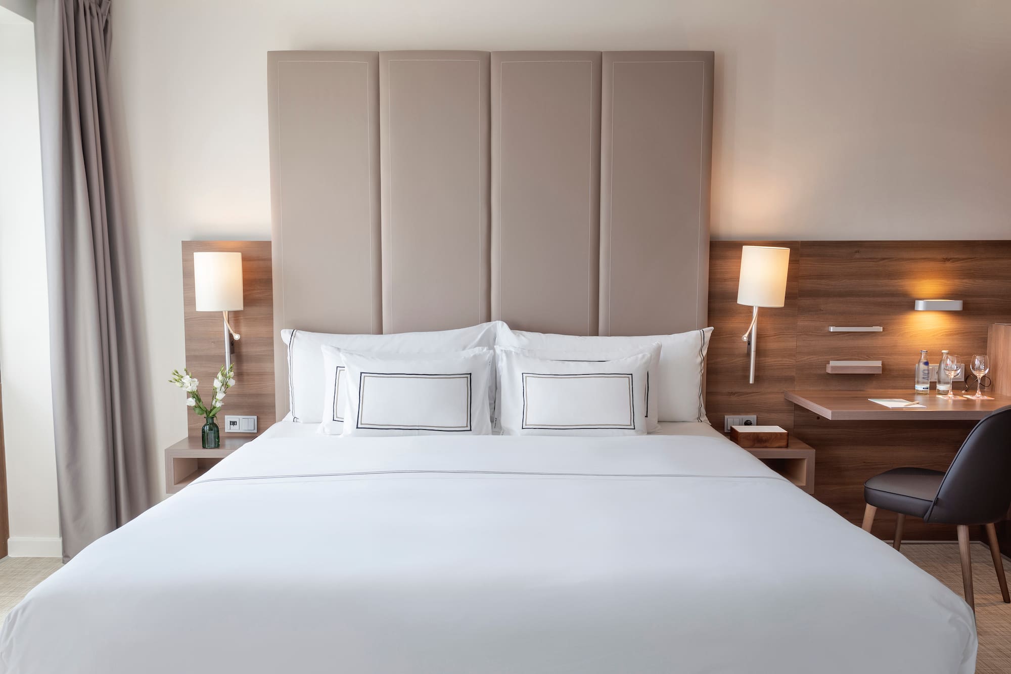a bed with white sheets and pillows