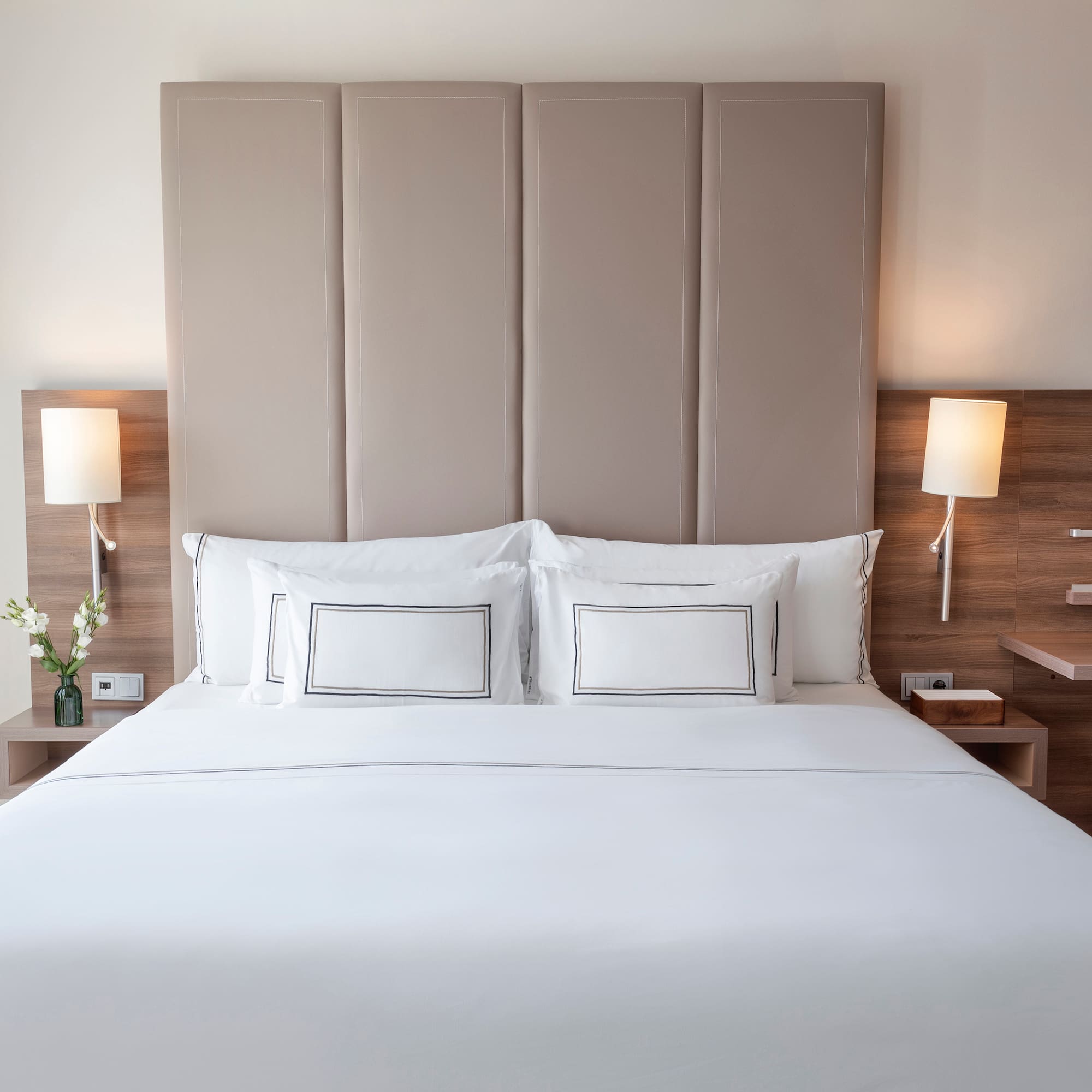 a bed with white sheets and pillows