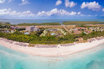 an aerial view of a beach with a pool and trees