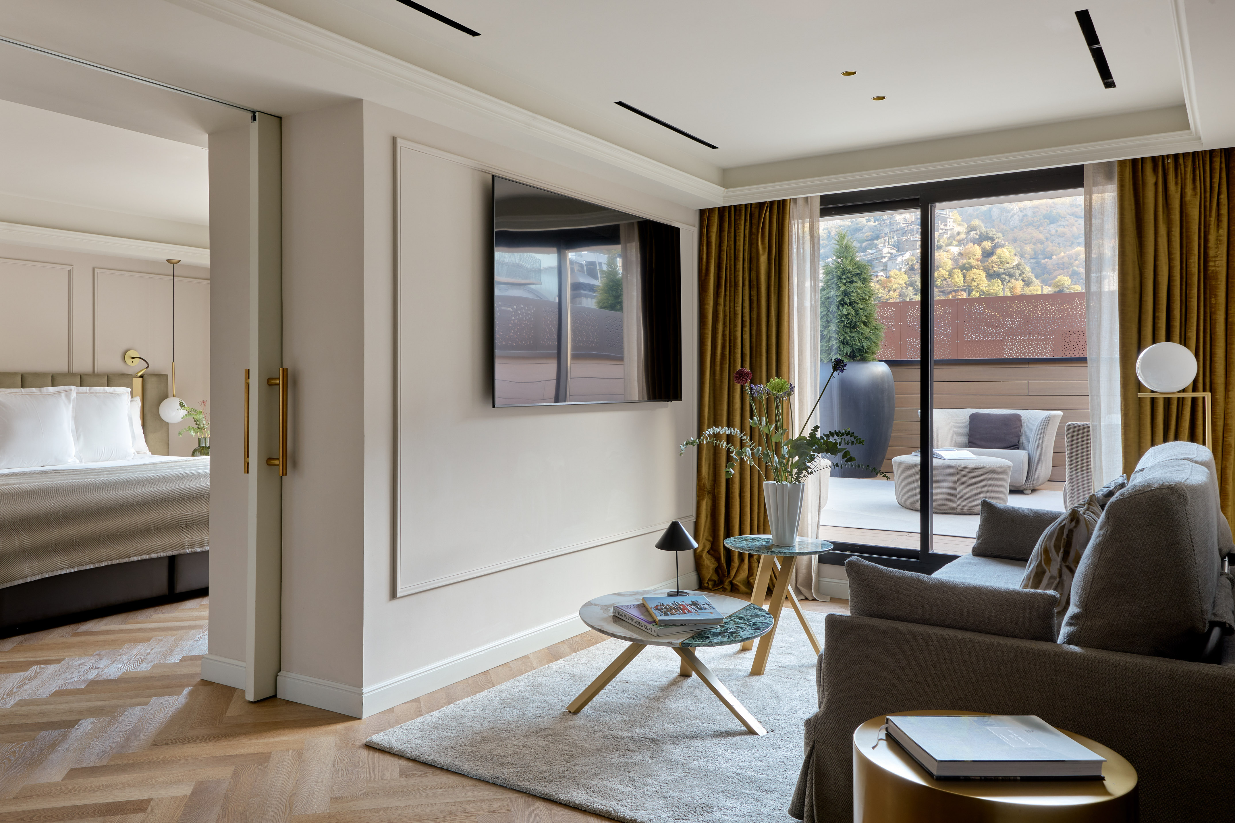 Lujosa suite: sala de estar, TV, balcón con vista a la montaña y dormitorio.