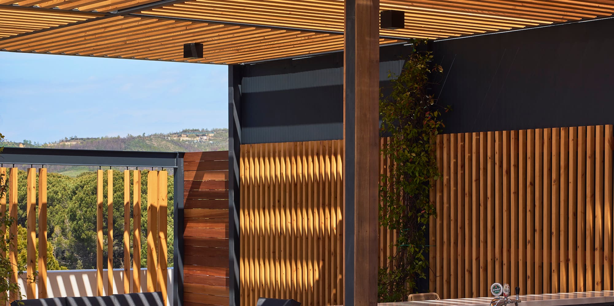 a patio with a wood structure and chairs