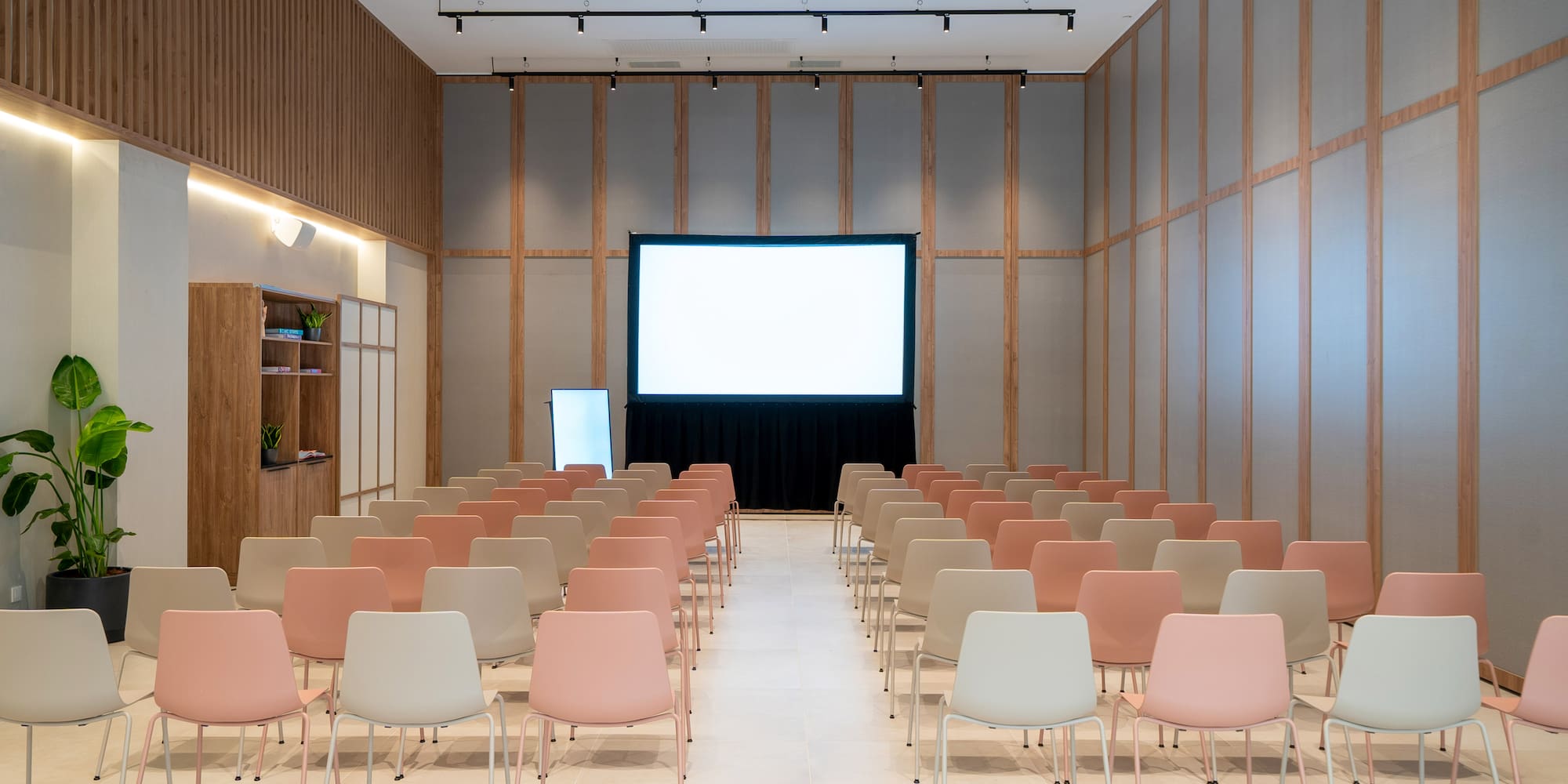 a room with rows of chairs and a projector screen