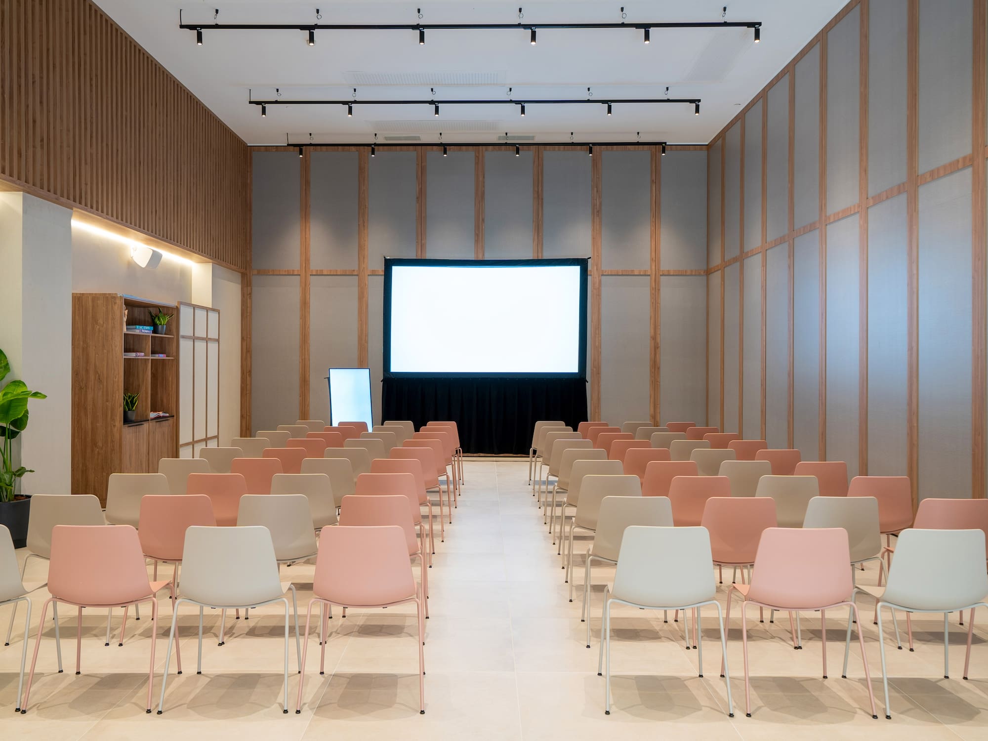 a room with rows of chairs and a projector screen