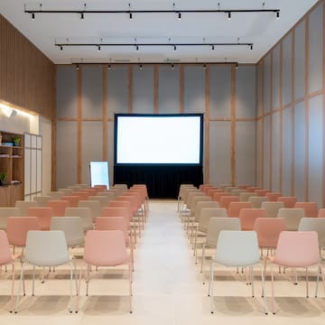 a room with rows of chairs and a projector screen