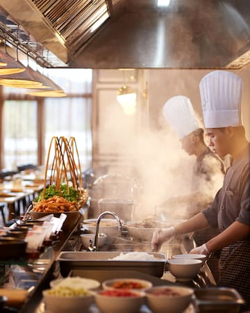 a group of chefs cooking in a kitchen
