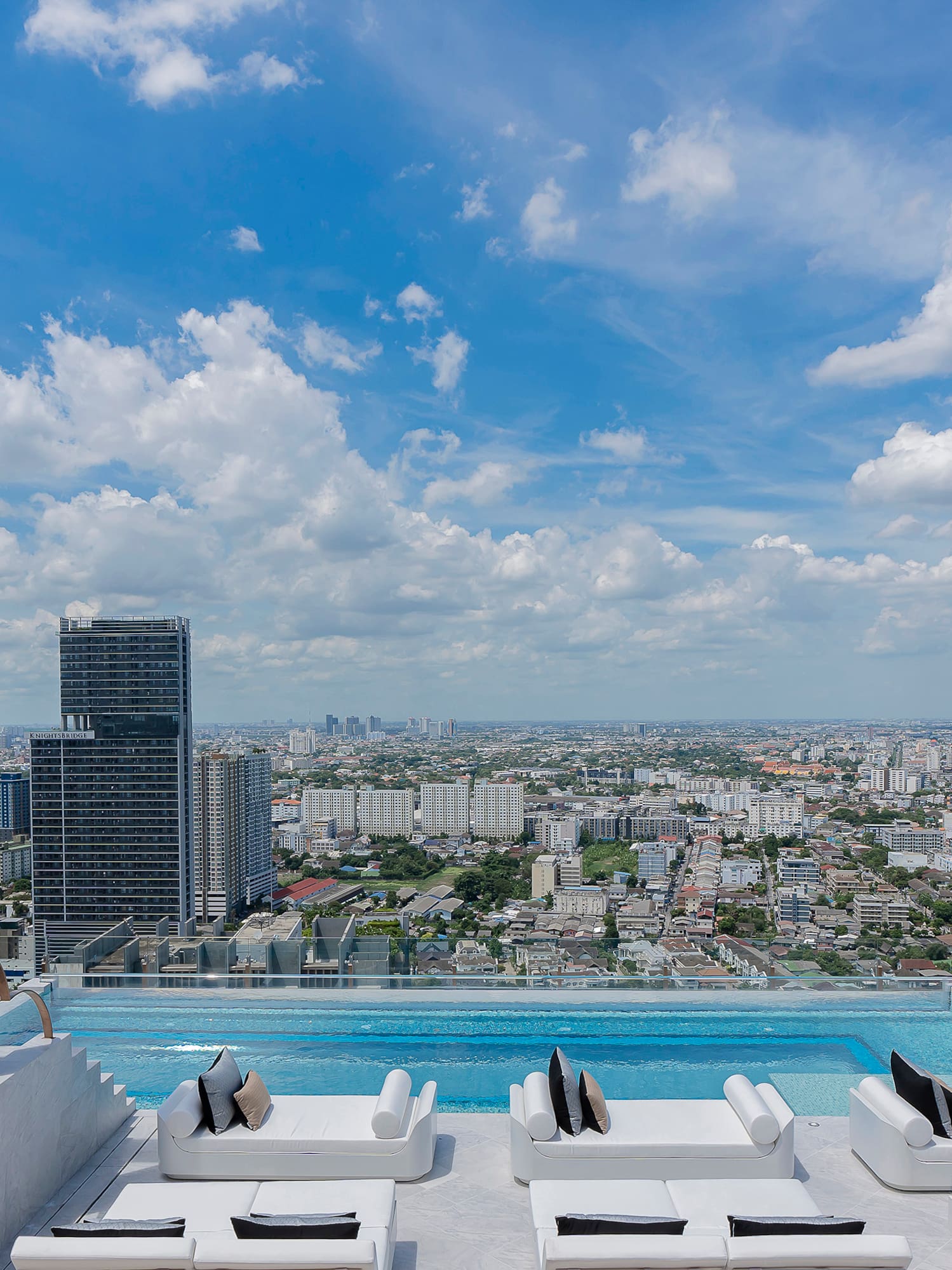 a pool with a view of a city and a blue sky