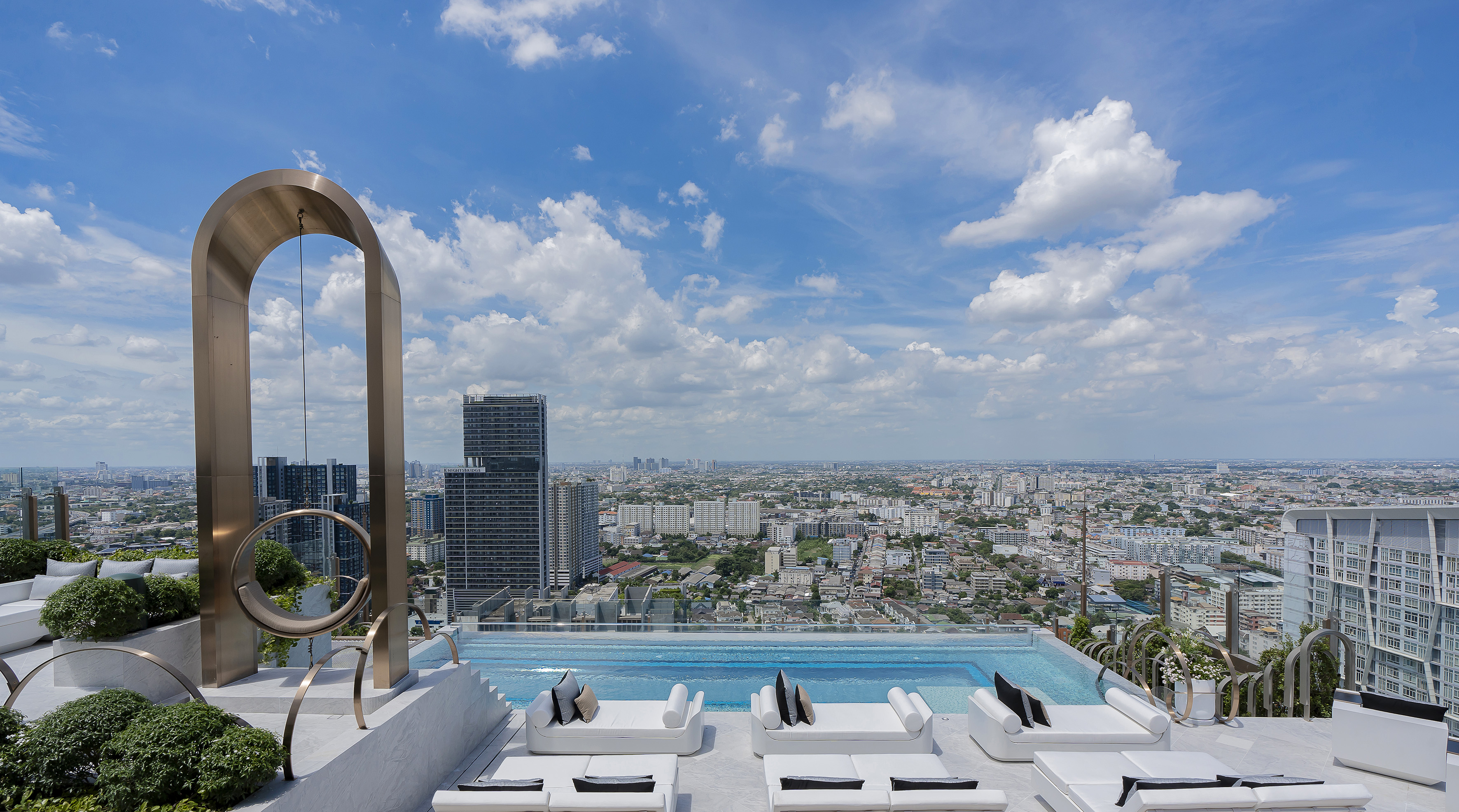 a pool with a view of a city and a blue sky
