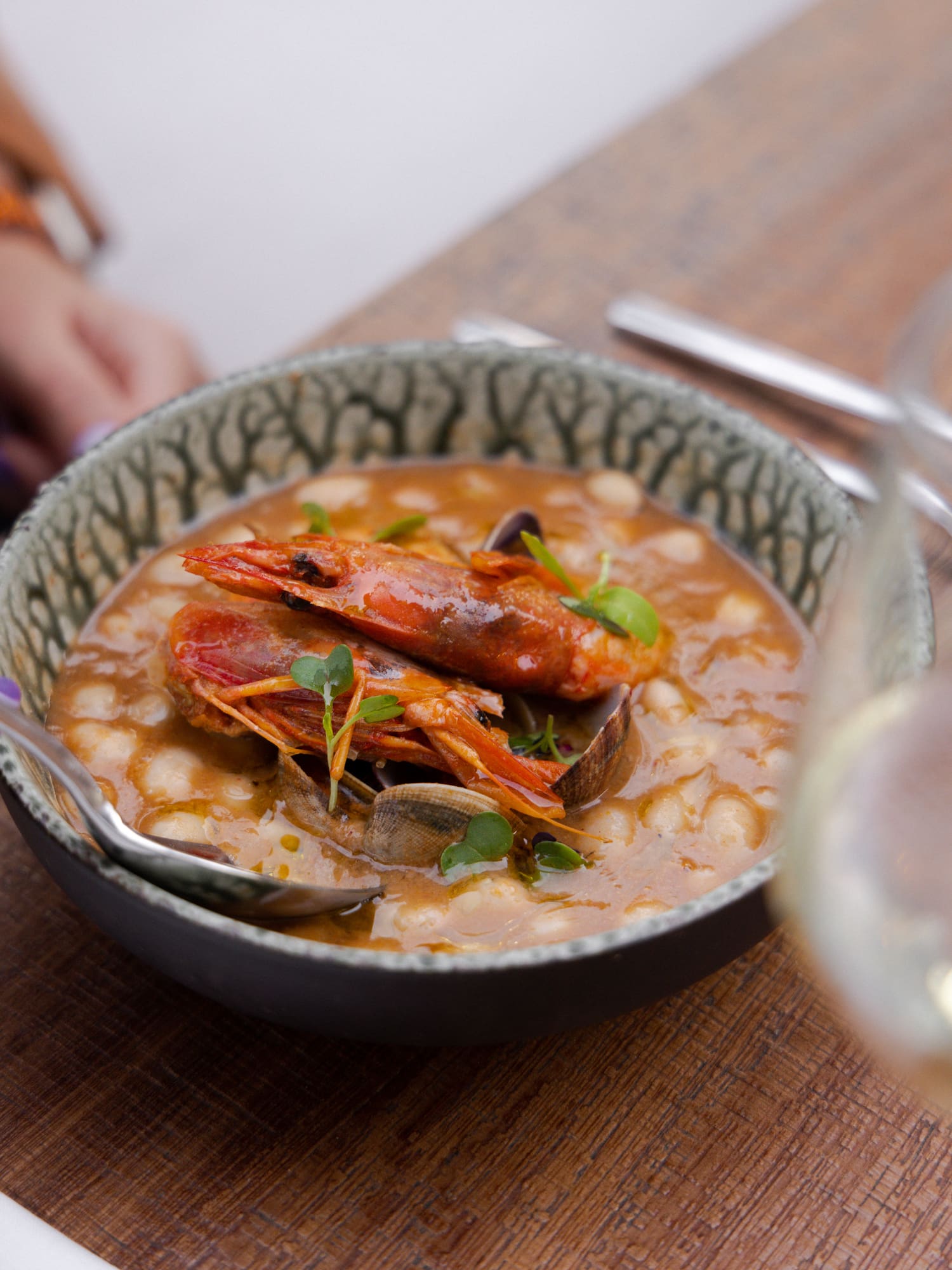 a bowl of soup with shrimp and vegetables