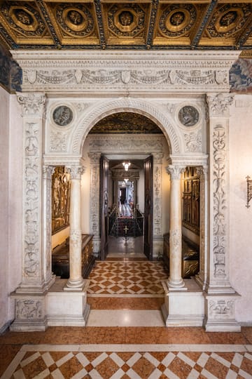 a hallway with ornate archways and a door