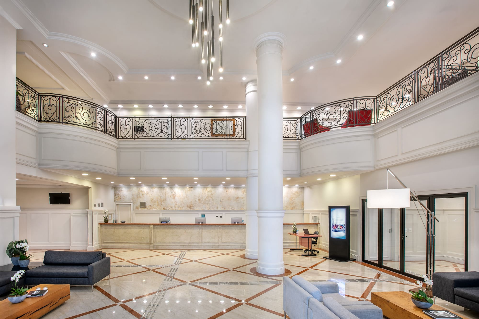 a large white room with a large white column and a large black railing