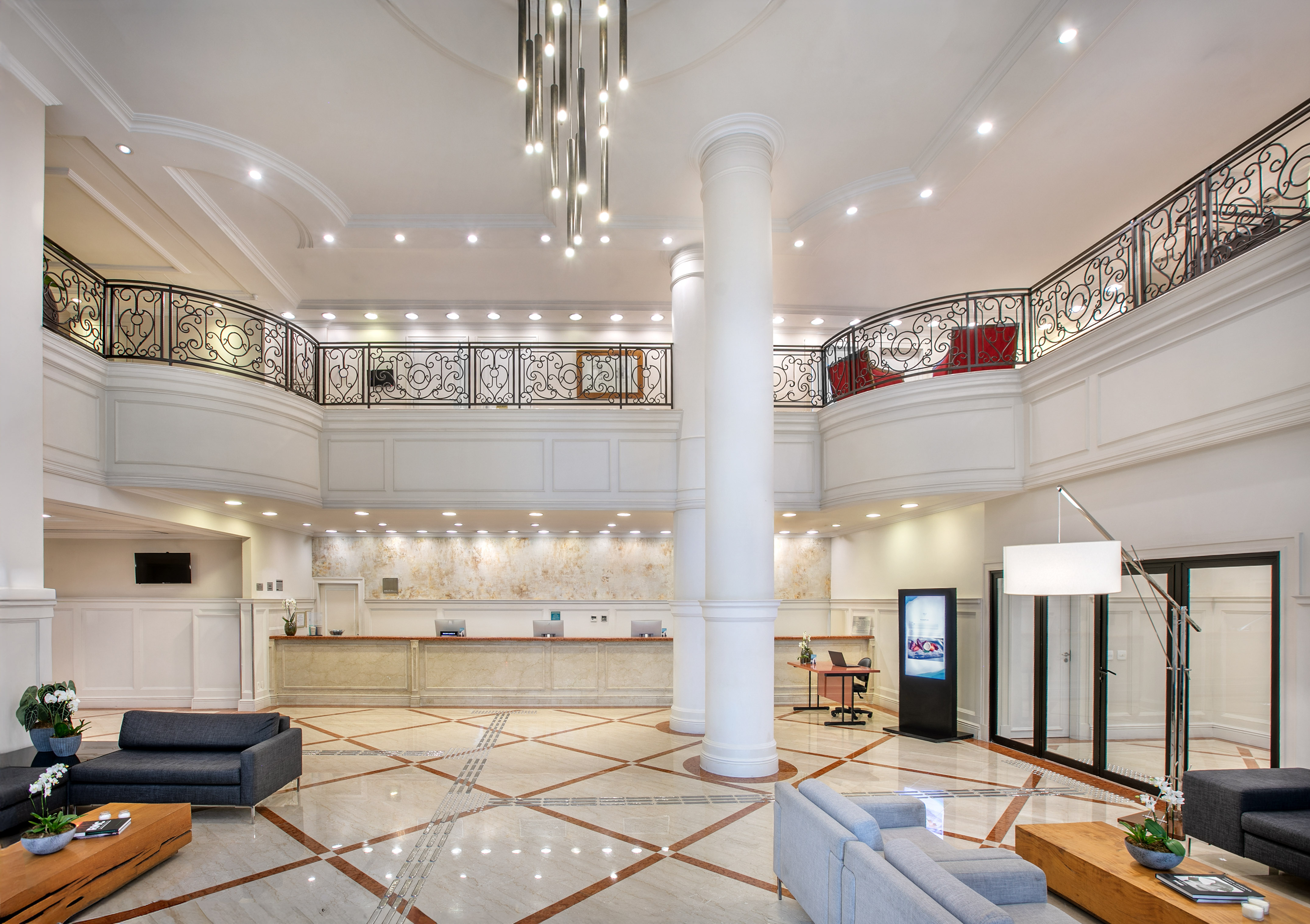 a large white room with a large white column and a large black railing