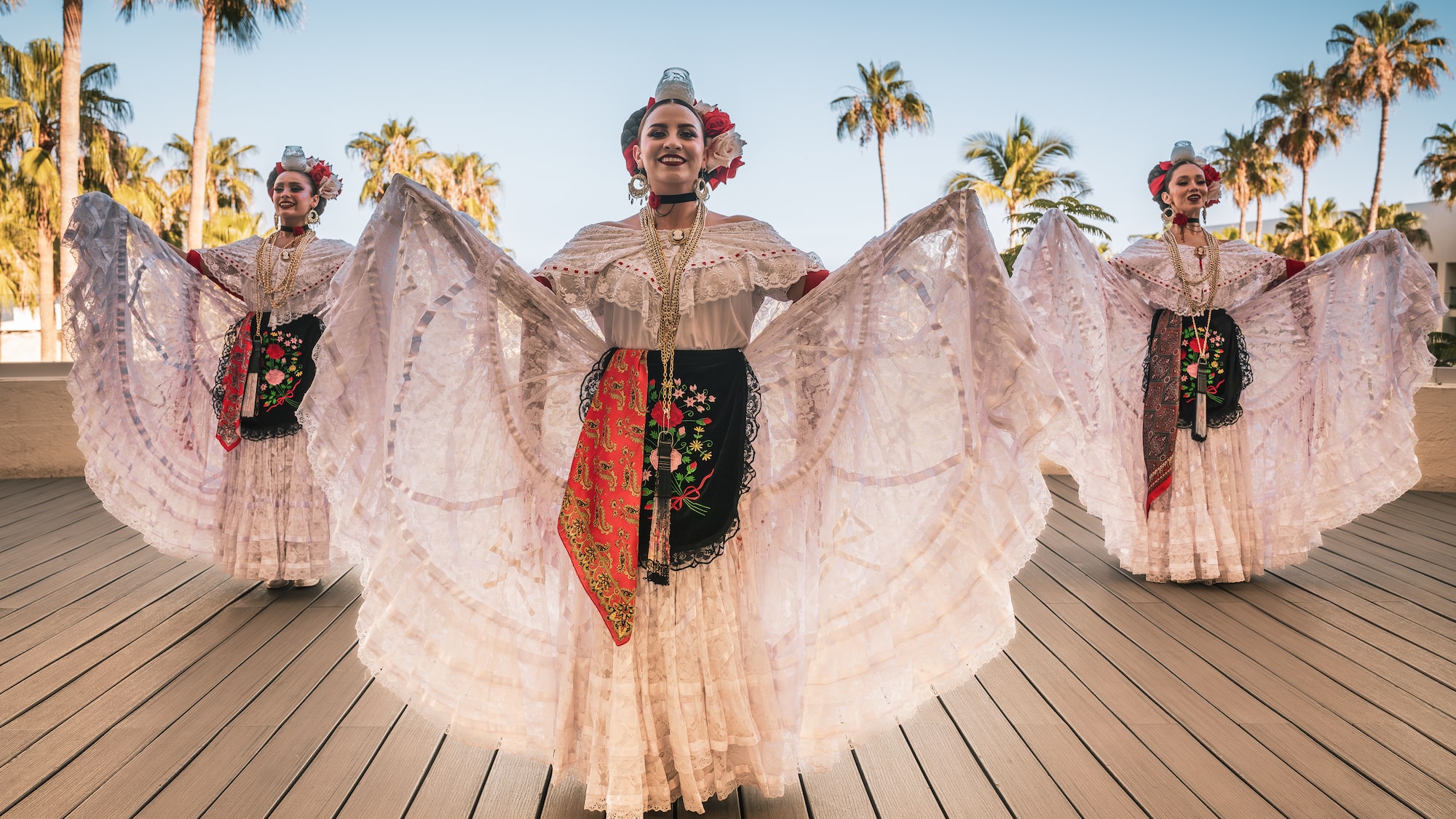a group of women wearing white dresses and flowers