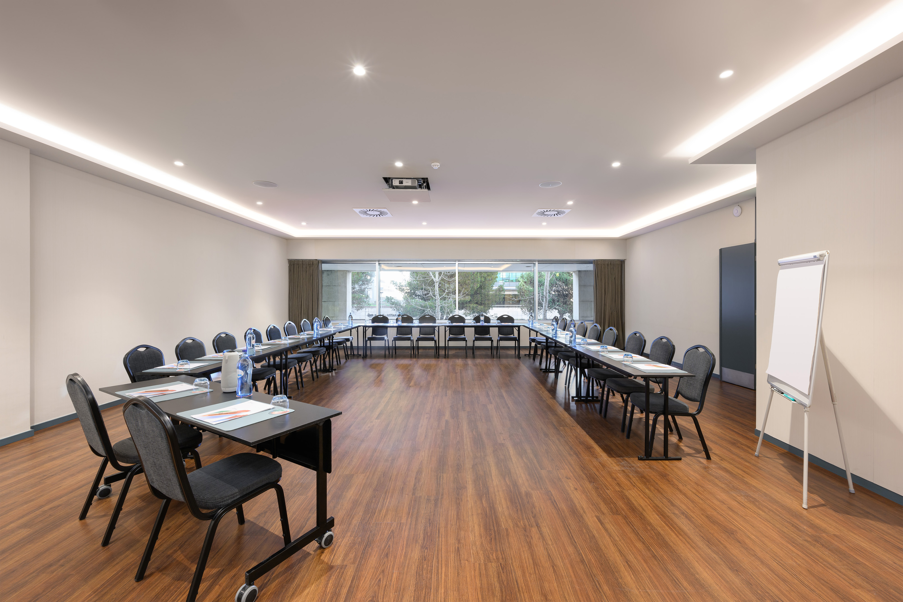 Professional U-shaped conference room with projector and large windows.