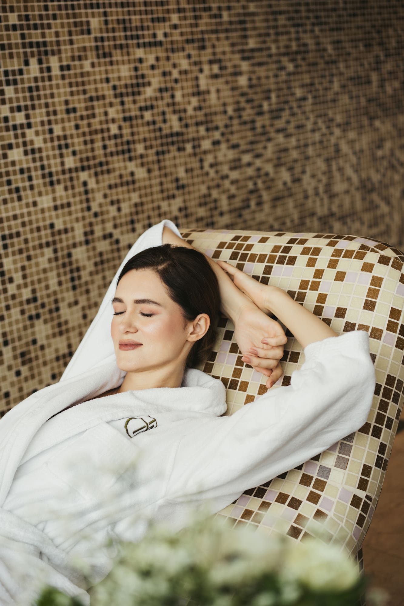 a woman lying on a chair with her eyes closed