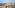Aerial view of a luxury oceanfront resort with modern hotels and villas.