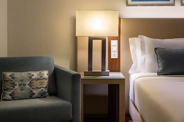 a lamp on a table next to a bed