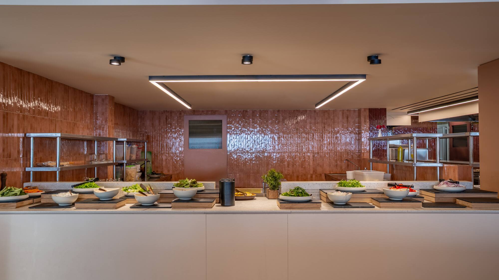 Modern self-serve salad bar buffet with fresh greens and ingredients.