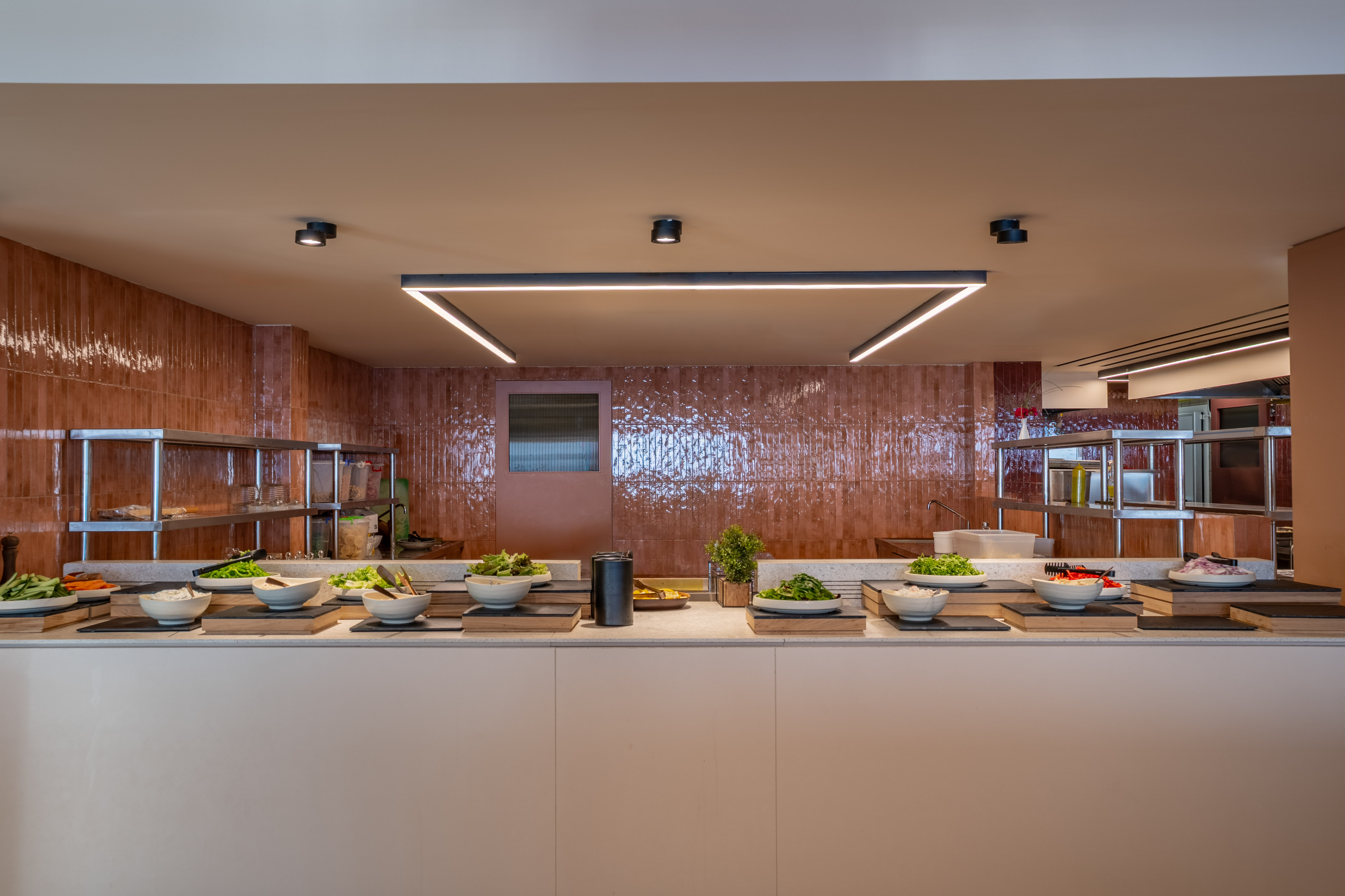 Modern self-serve salad bar buffet with fresh greens and ingredients.