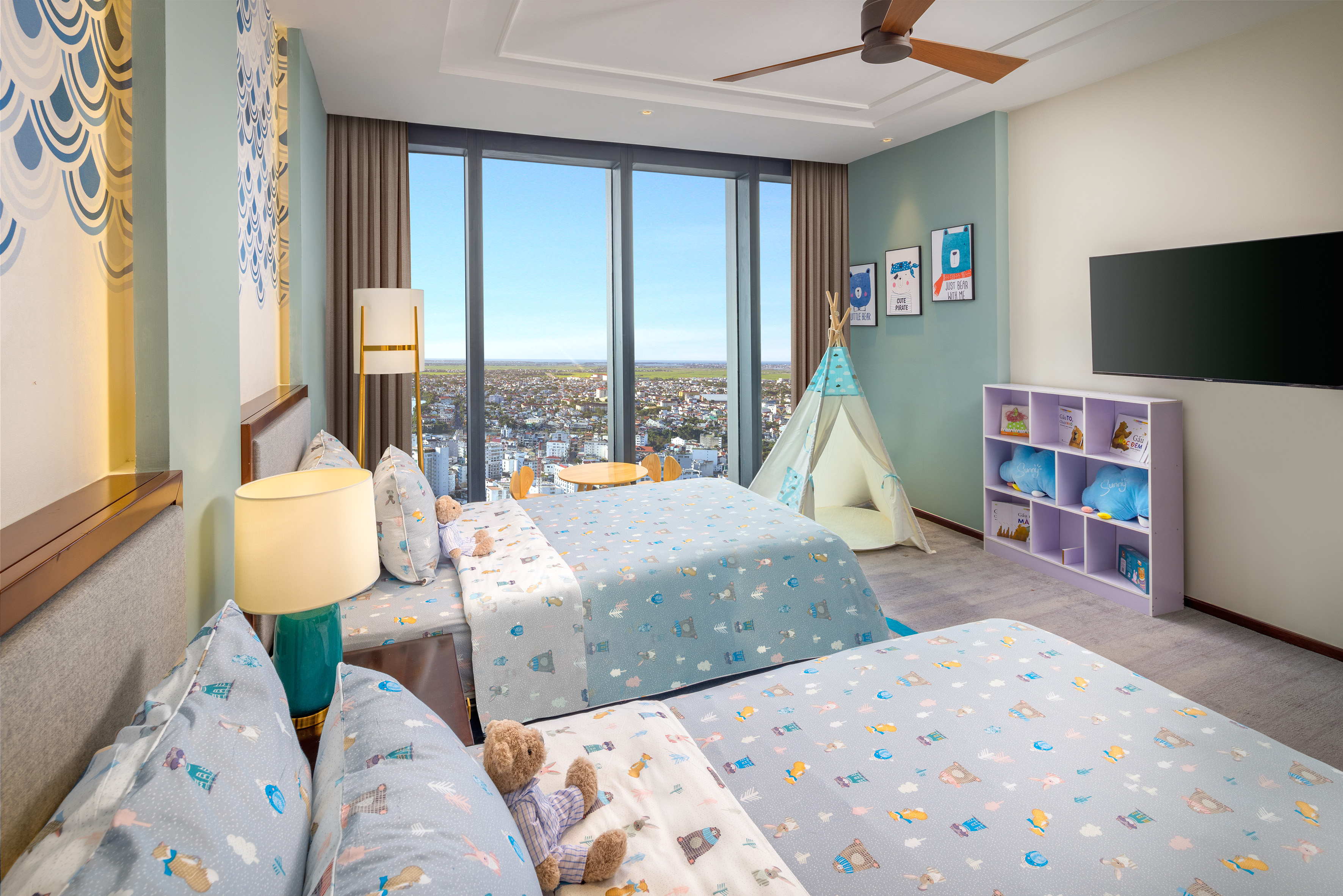 Kids' room with two beds, city view, teepee, and playful animal bedding.