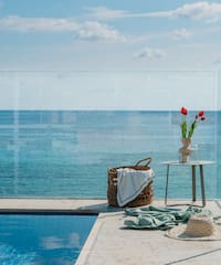 a pool with a glass fence and a basket and a vase of flowers