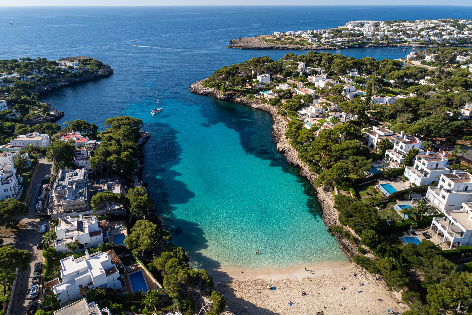 Cala d'Or, Mallorca aerial: White villas, green trees, turquoise coves, boats.