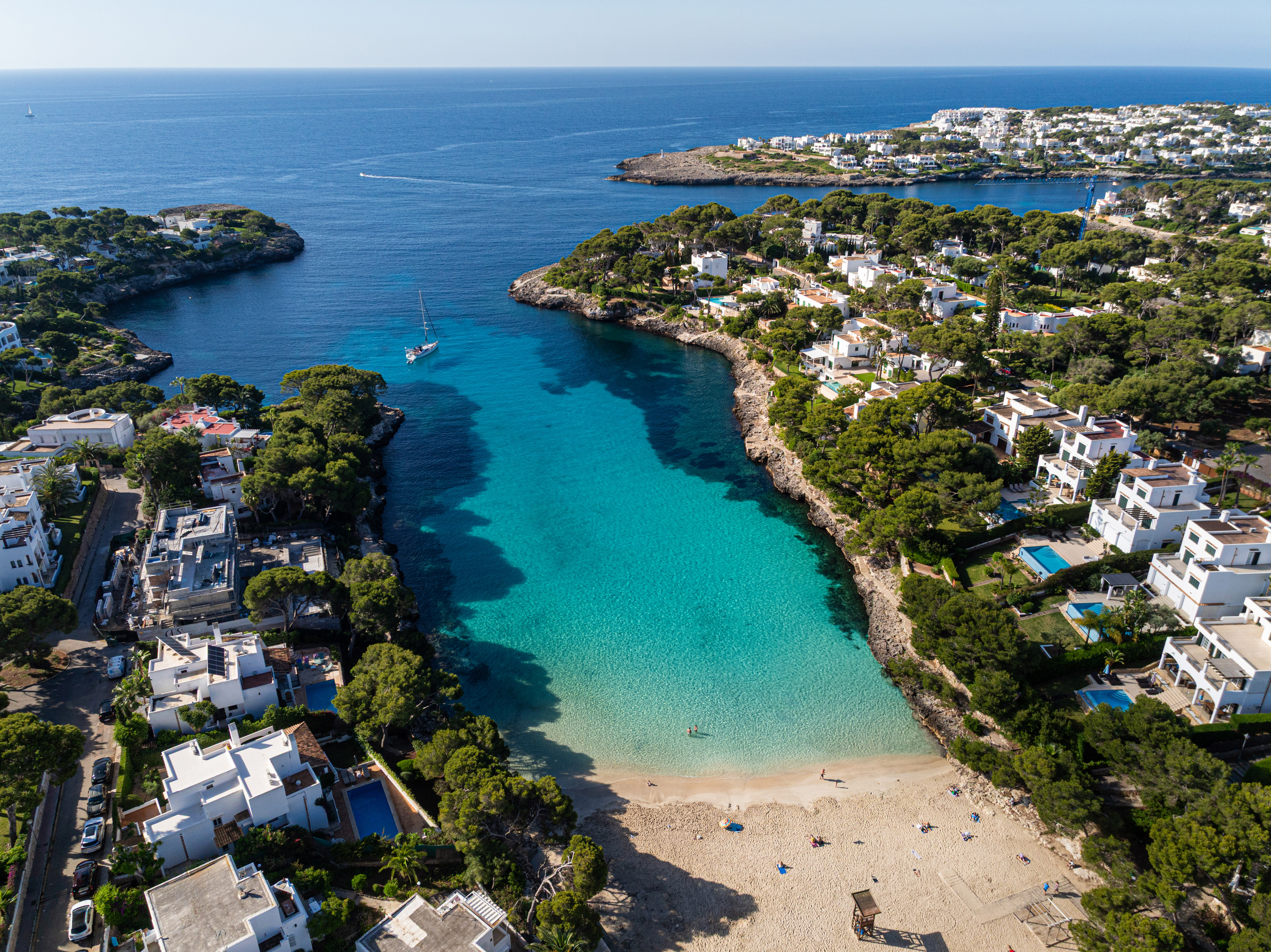 Cala d'Or, Mallorca aerial: White villas, green trees, turquoise coves, boats.