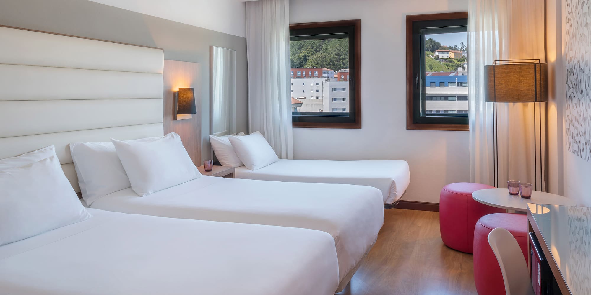 a room with two beds and a red stool