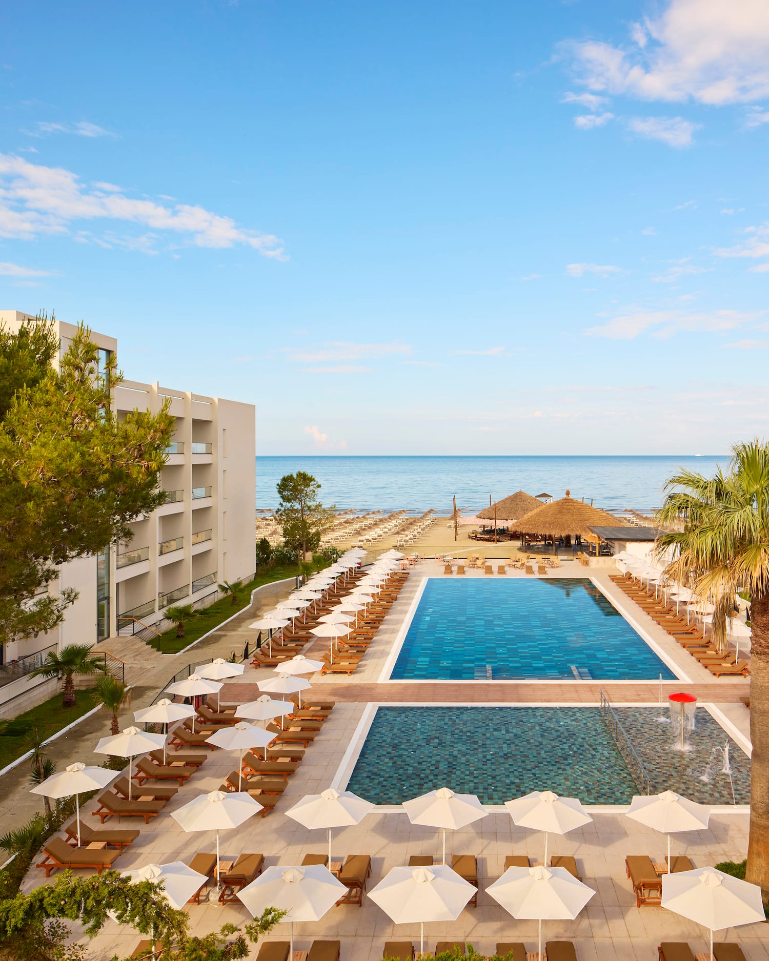 a pool and umbrellas by a building