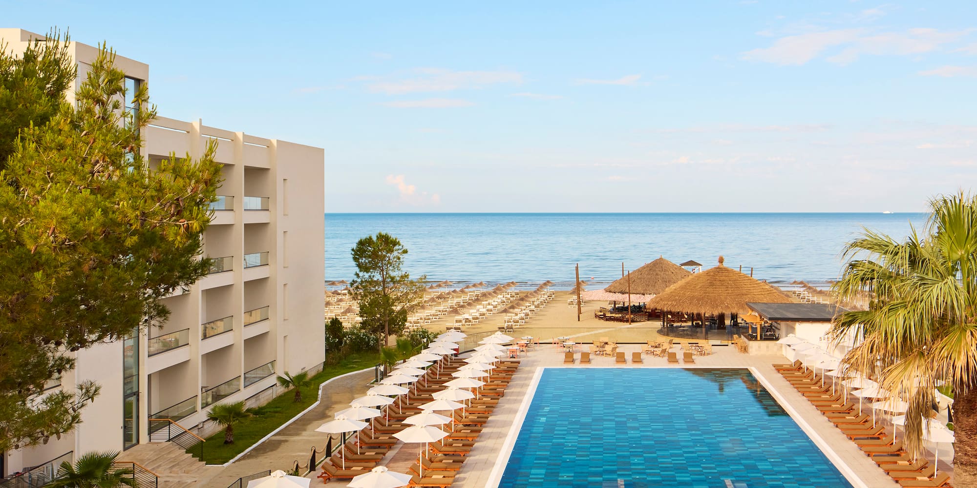 a pool and umbrellas by a building