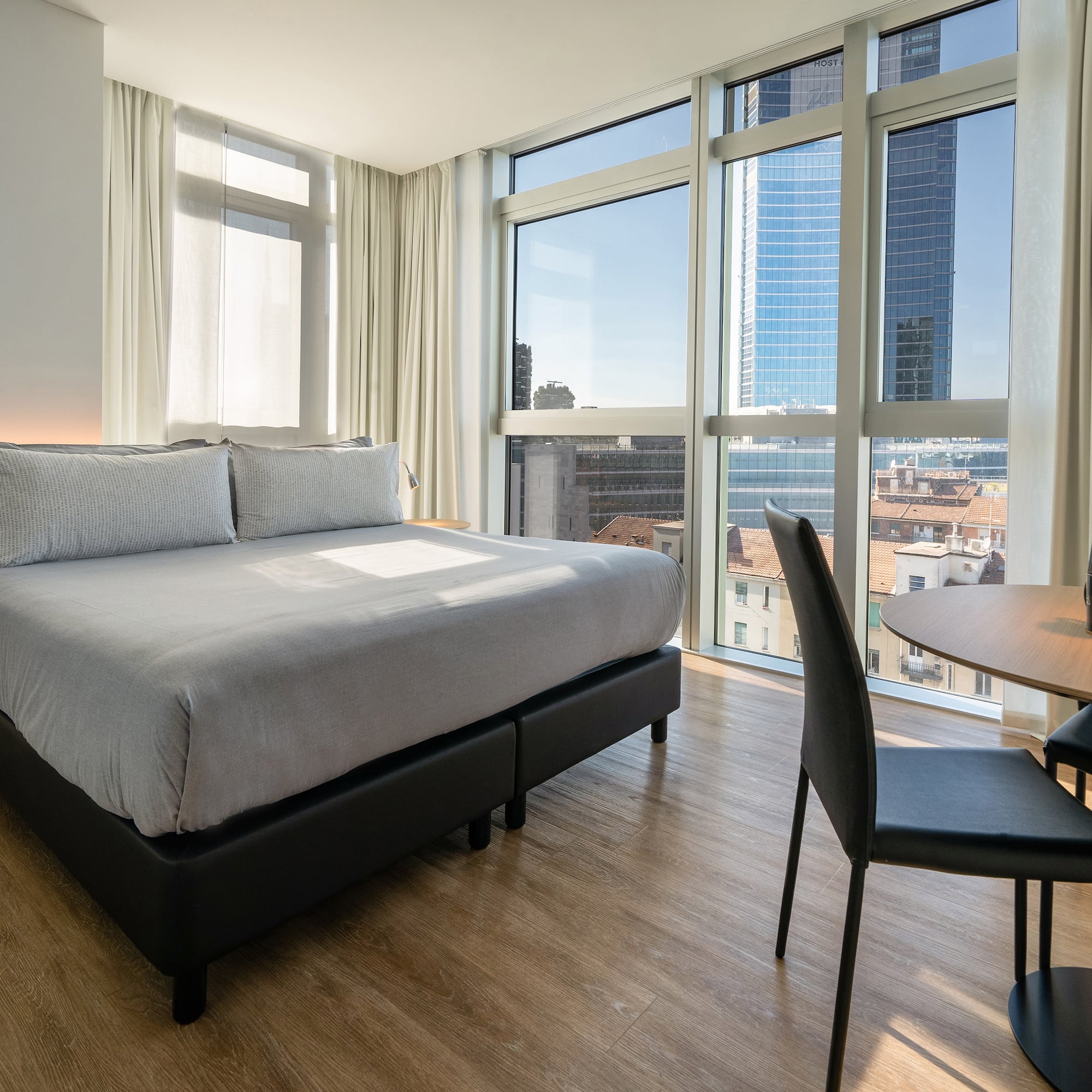 a room with a bed and a table and chairs