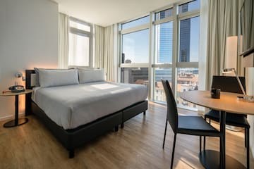 a room with a bed and a table and chairs