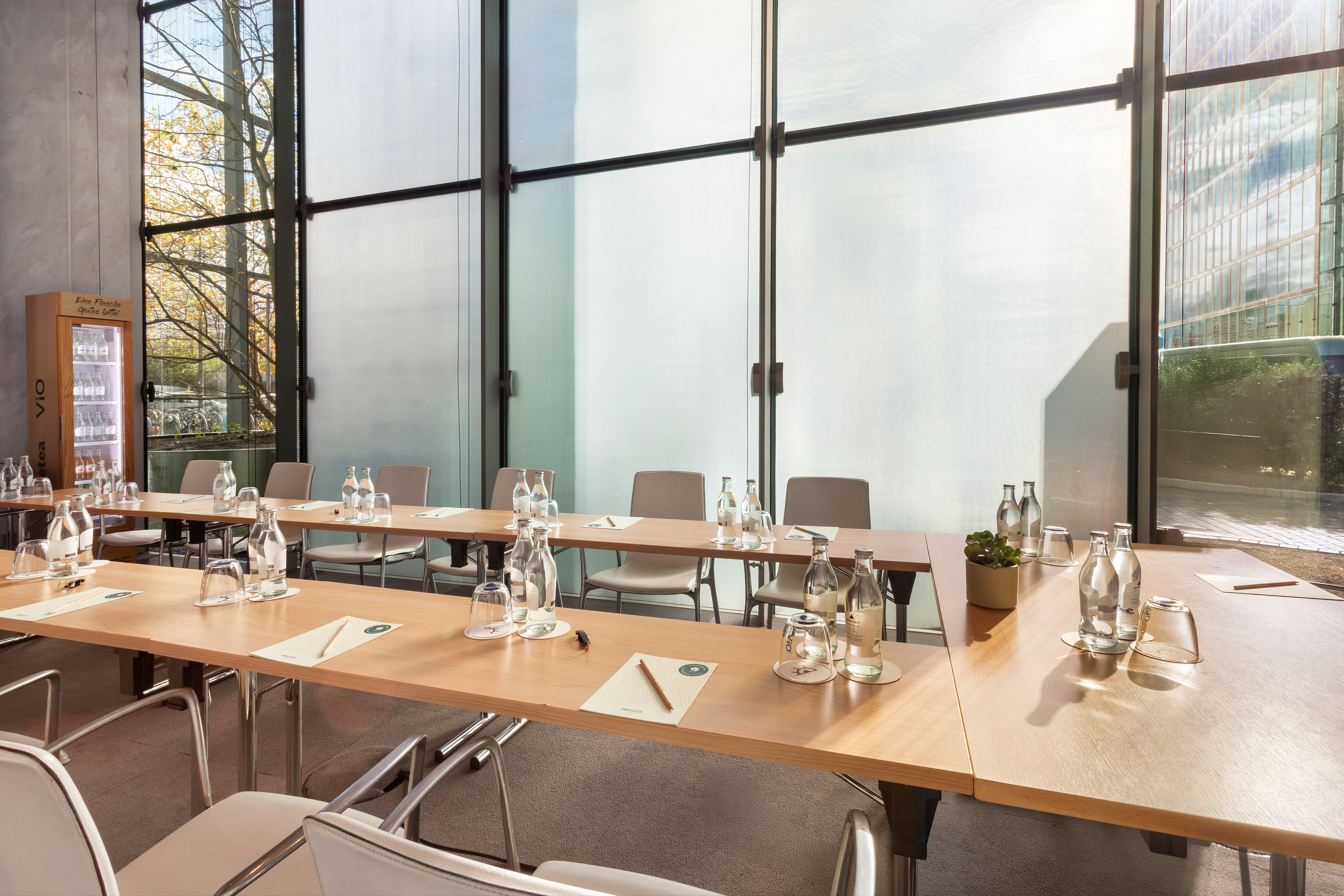 Modern conference room with wooden table, water bottles, and large windows.
