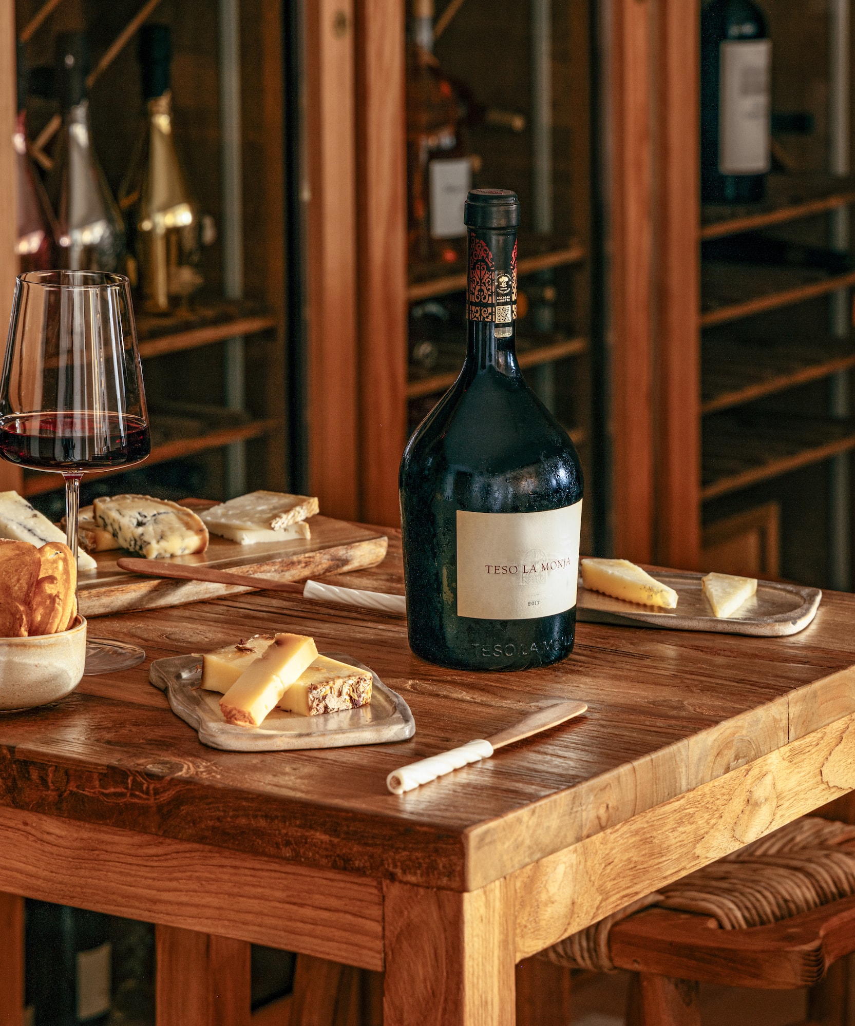a table with a bottle of wine and cheese on it